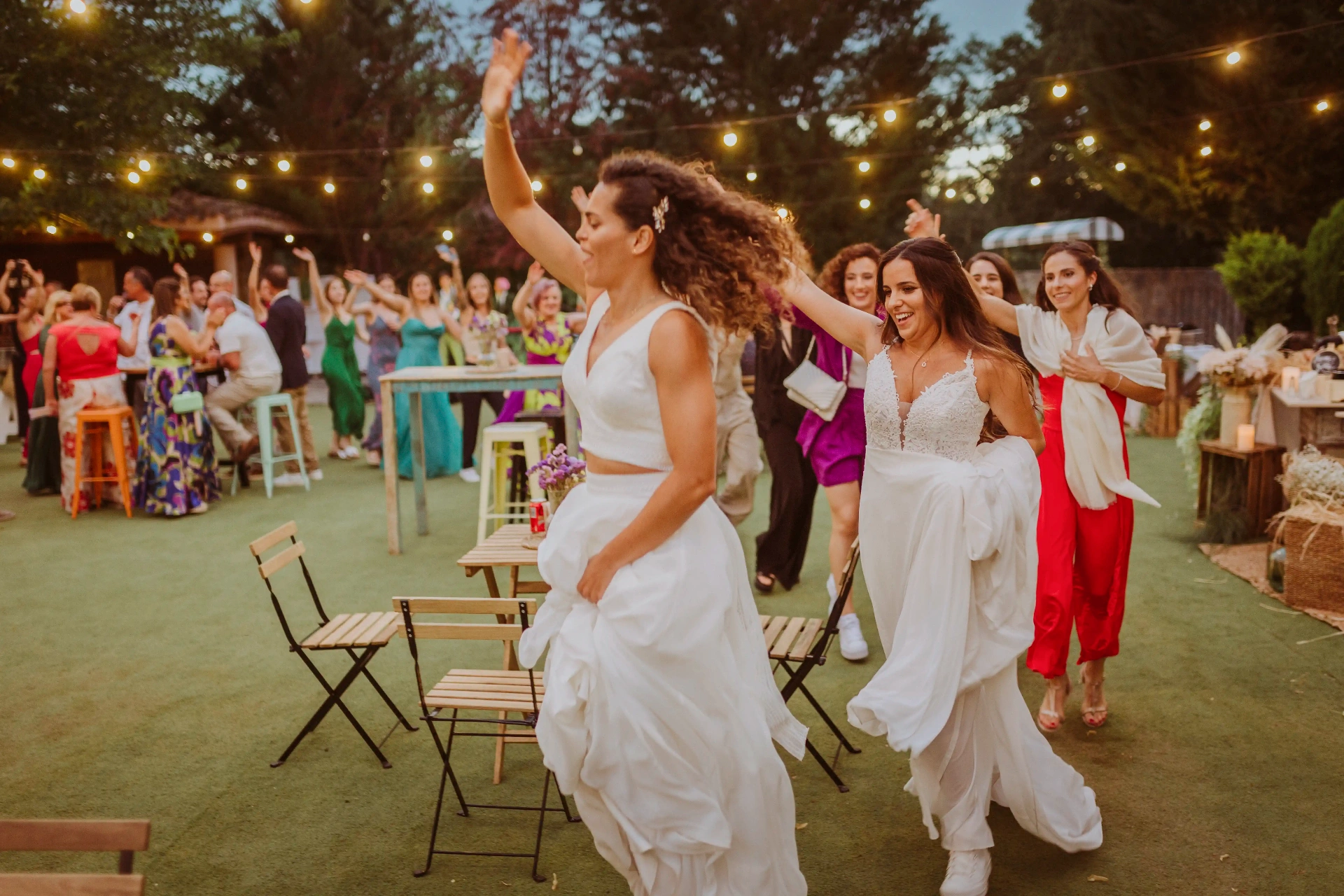 boda LGTBI en El Xaloc, Calders — las novias entran corriendo a la pista de baile bajo las luces de feria