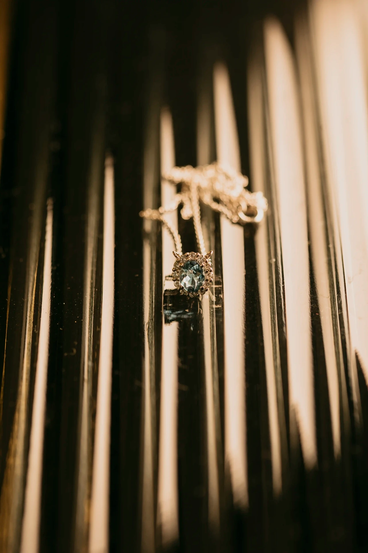 Detalle de colgante con piedra azul sobre superficie brillante, joyería nupcial boda Lleida