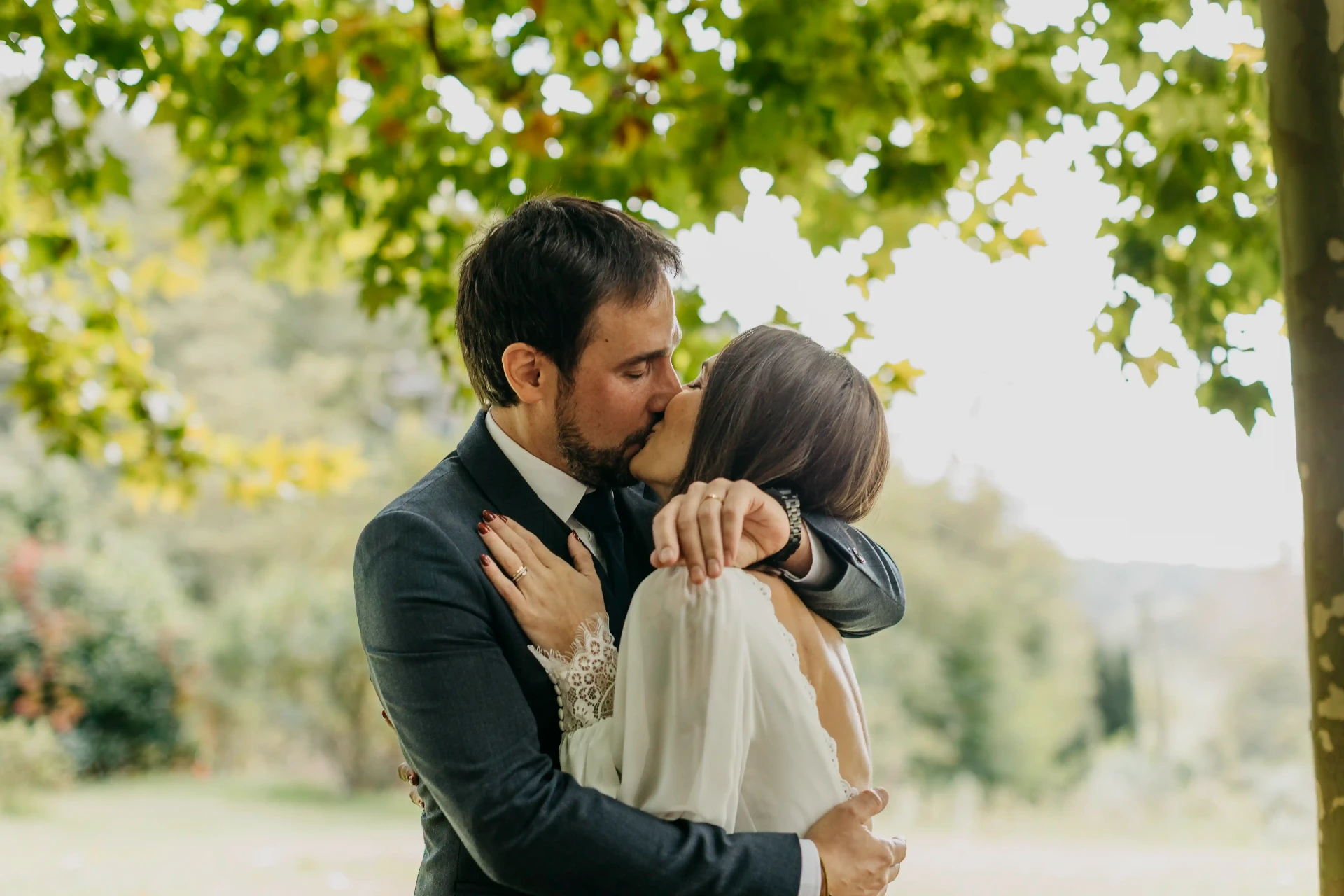 Beso íntimo y abrazado de Carla y Dani tras la ceremonia bajo el plátano en Can Riera de la Pineda