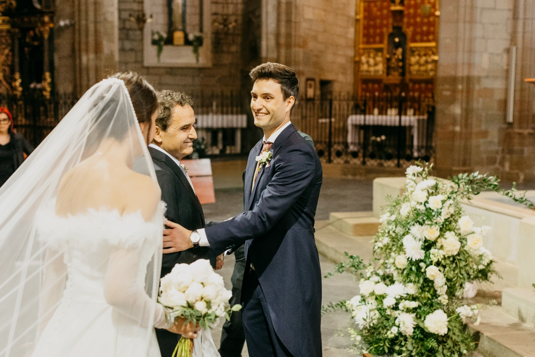 Padre entregando a la novia al novio sonriente en el altar de Santa Maria de Cervera, boda Lleida
