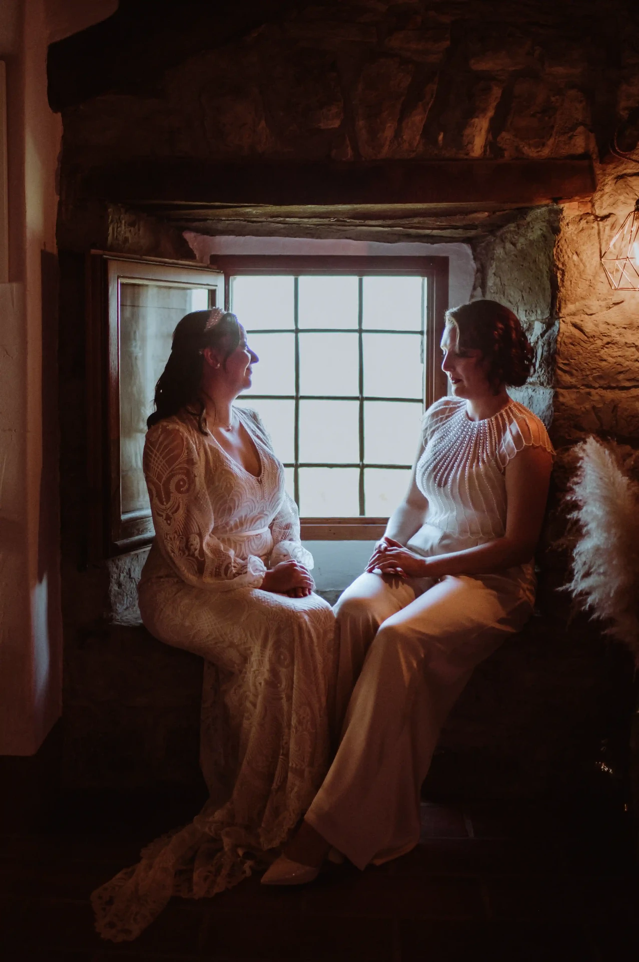 Retrato de las dos novias sentadas frente a la ventana de piedra en This Must Be The Place, Moianès