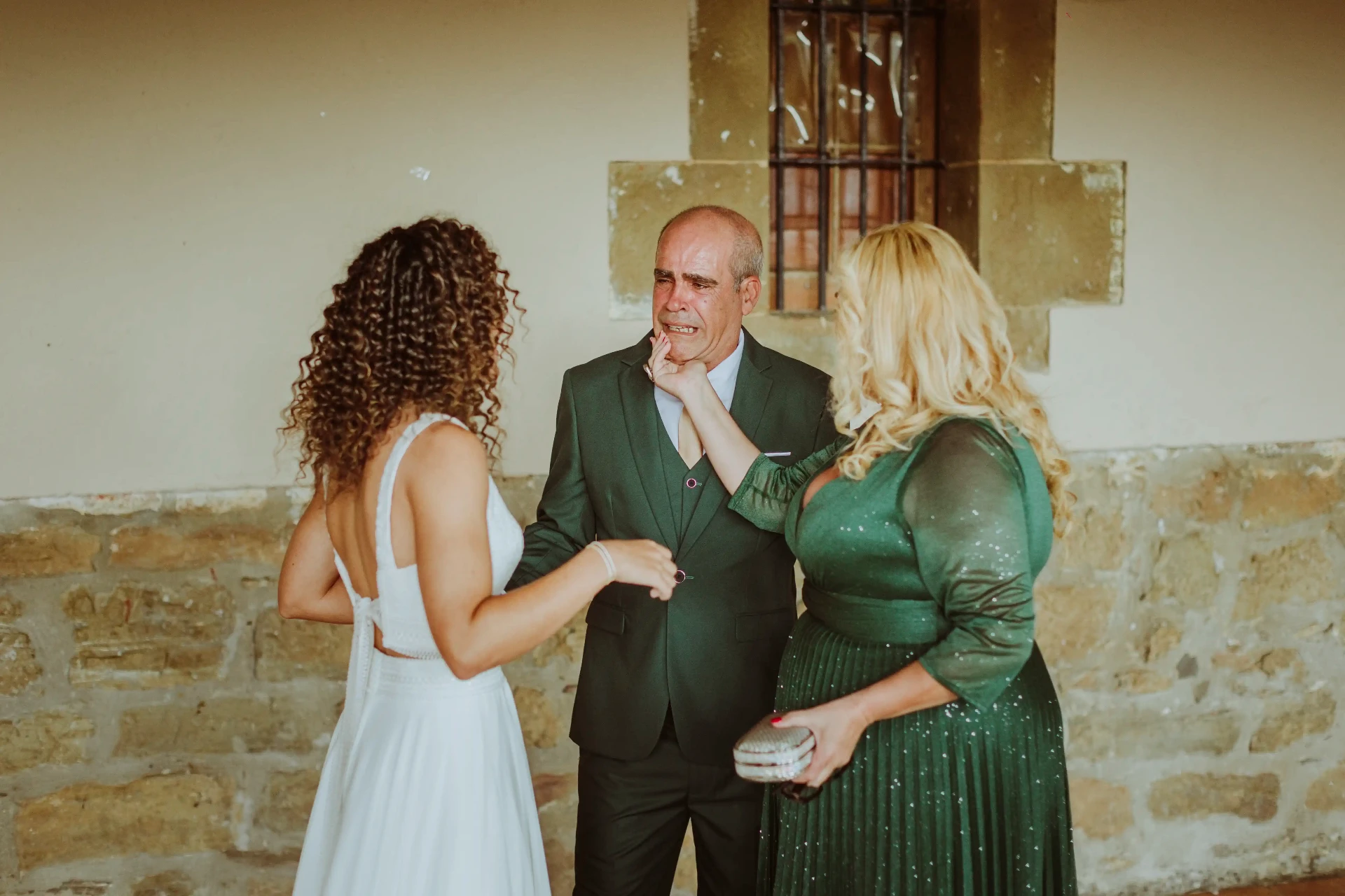 boda LGTBI en El Xaloc, Calders — el padre de la novia llora mientras ella y su madre le consuelan