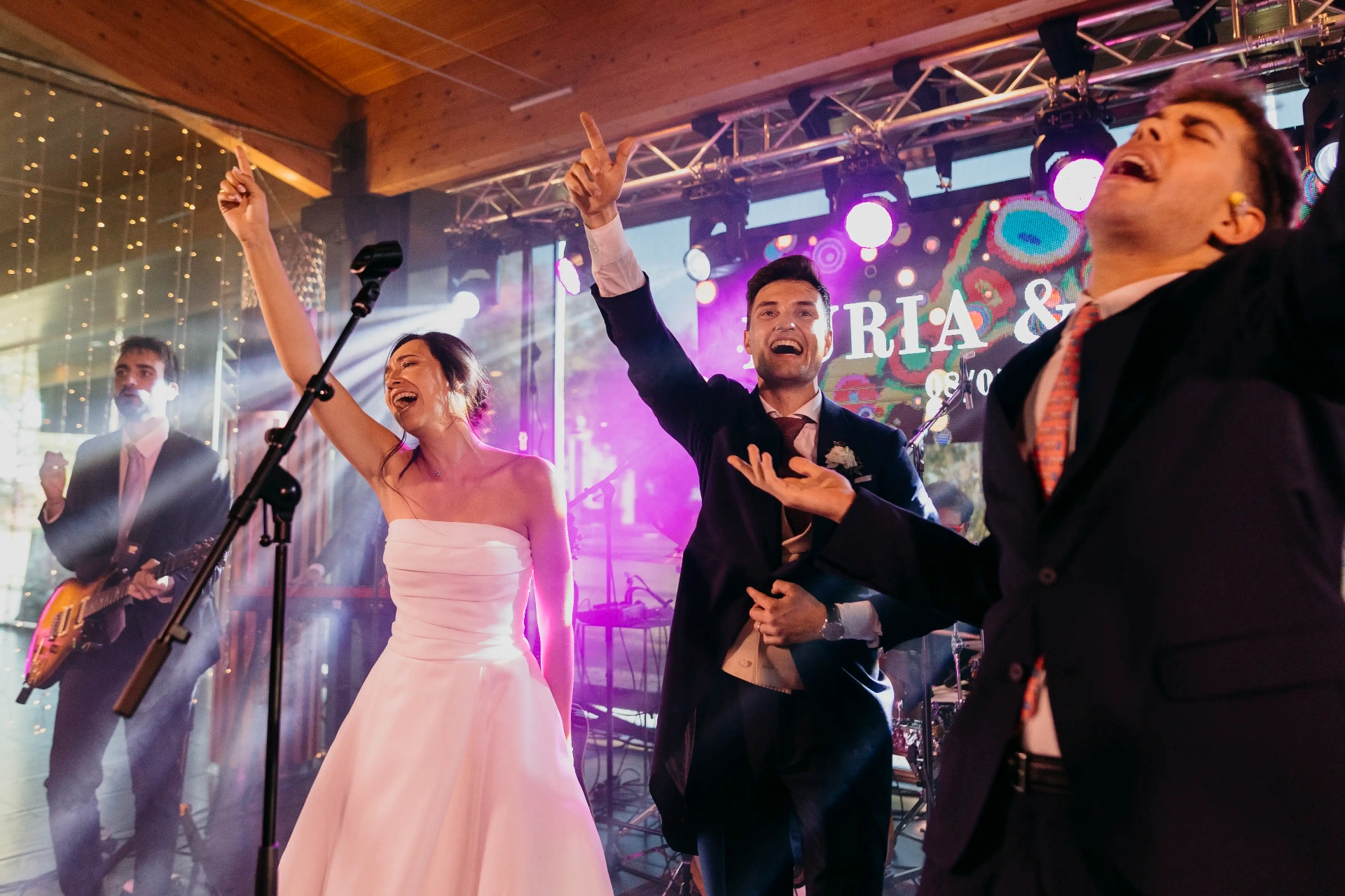 Novios cantando y bailando en el escenario junto a la banda de música en directo, fiesta boda La Boscana Lleida