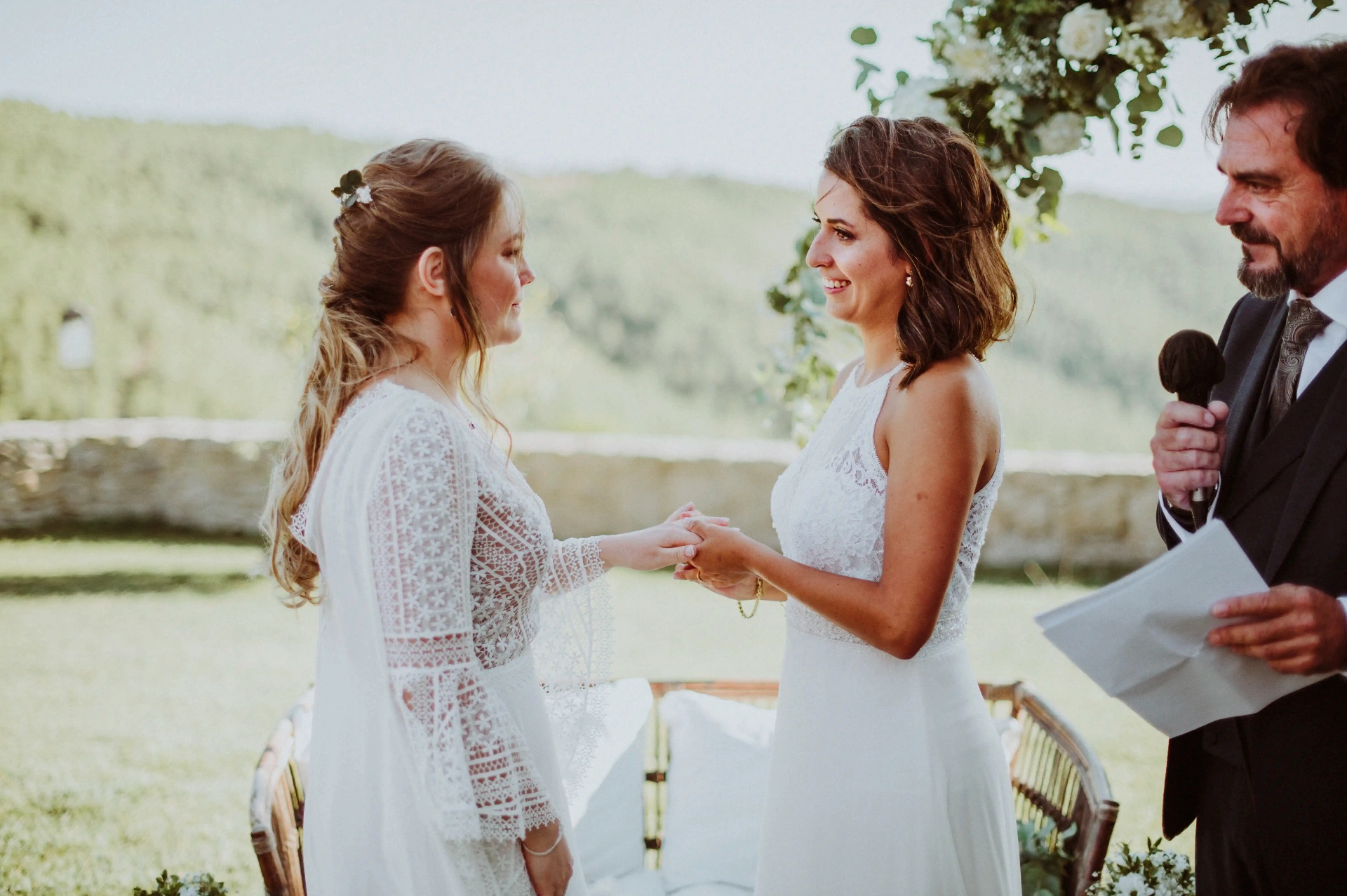 boda LGTBI en Ca n'Alzina — novias intercambiando los votos ante el oficiante con las montañas de Rubió al fondo