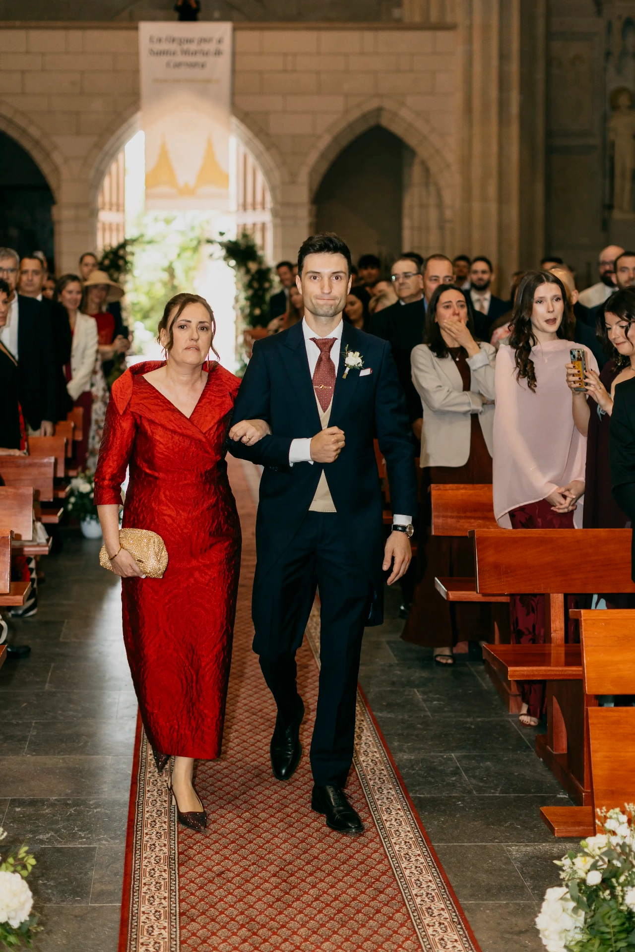 Entrada del novio del brazo de su madre en Santa Maria de Cervera, ceremonia boda Lleida
