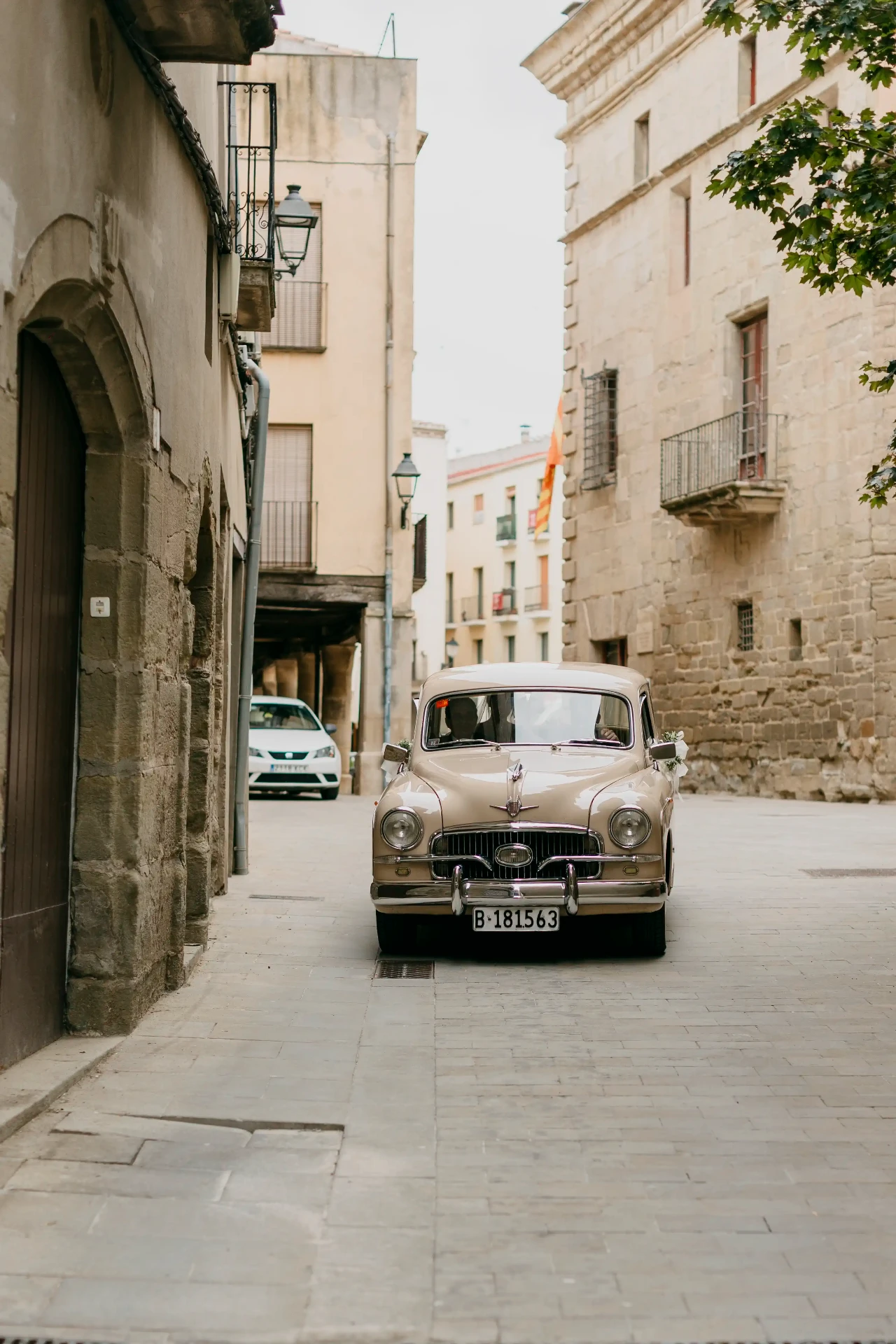 Coche clásico de novios llegando por las calles de Cervera, boda en La Boscana Lleida