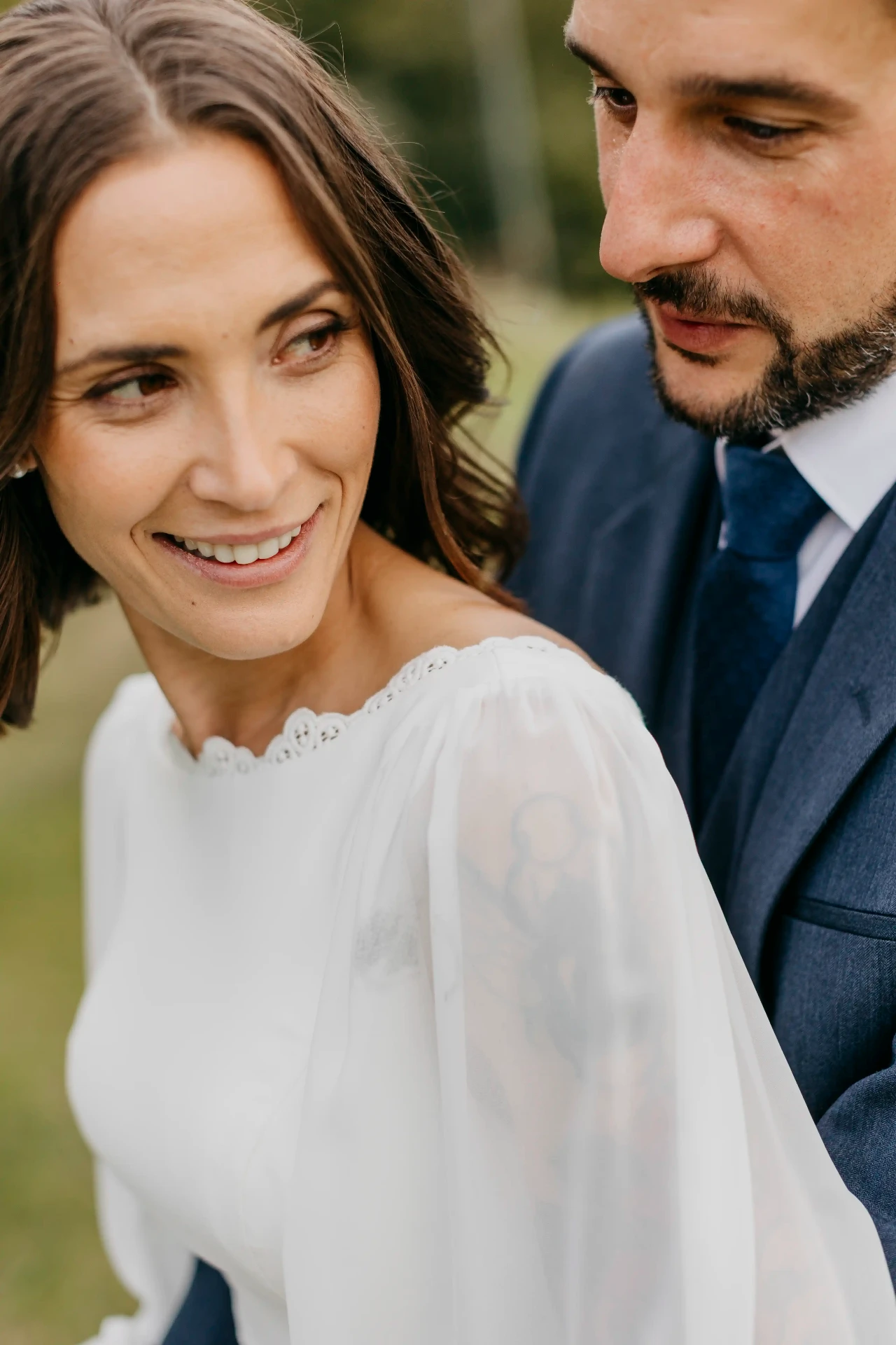 Retrato cercano de Carla sonriendo con Dani a su lado durante la sesión de pareja en Can Riera de la Pineda