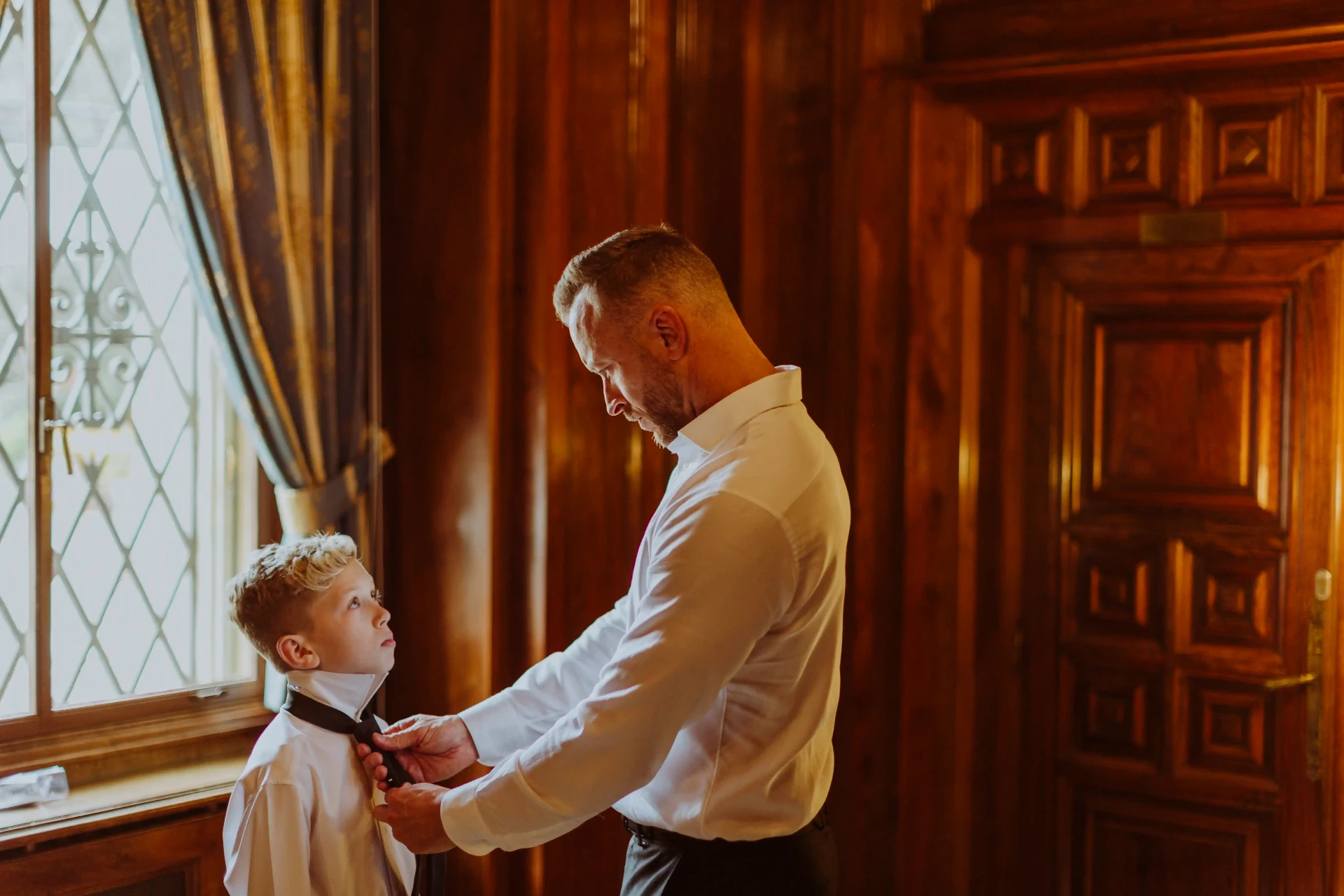 Lee ayudando a su hijo con la corbata en la sala de caballeros de Bell Recó