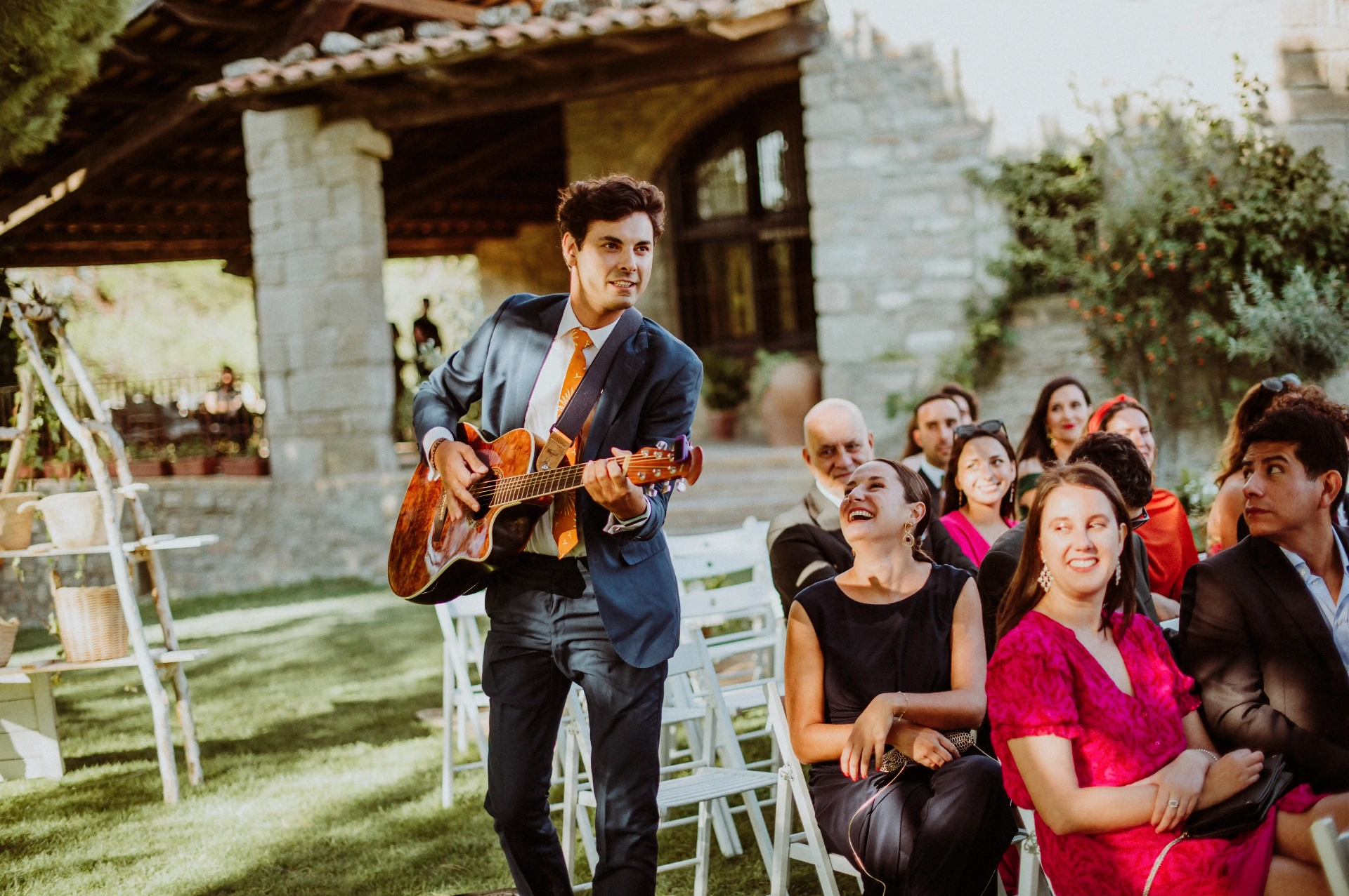 boda LGTBI en Ca n'Alzina — músico tocando la guitarra en directo durante la ceremonia con la masía de fondo