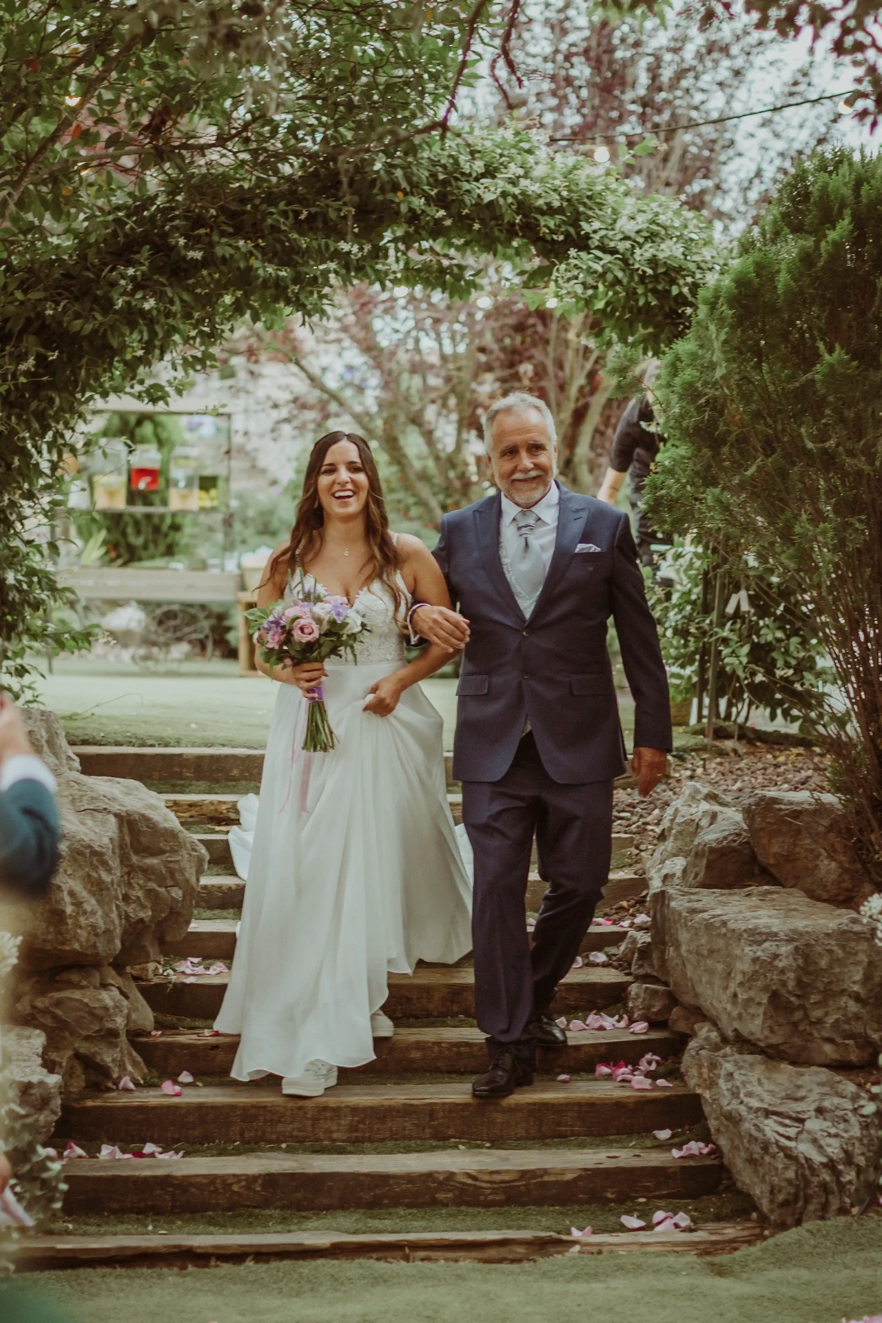 boda LGTBI en El Xaloc, Calders — la otra novia entra a la ceremonia del brazo de su padre riendo