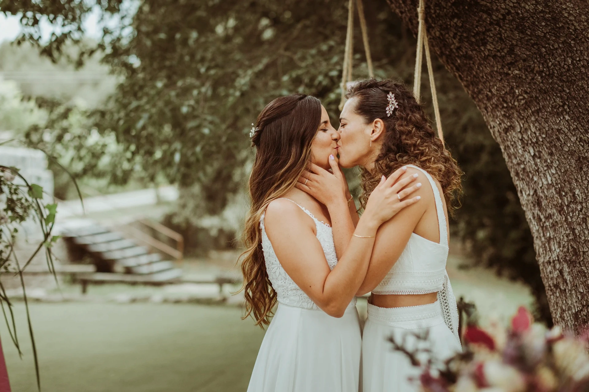 boda LGTBI en El Xaloc, Calders — primer beso de las novias al final de la ceremonia bajo el árbol