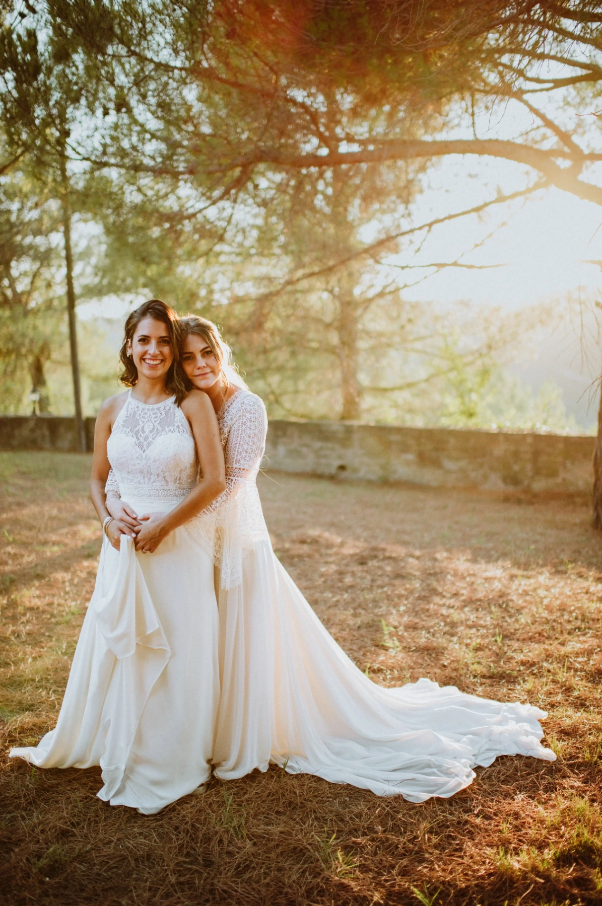 boda LGTBI en Ca n'Alzina — retrato de las novias sonrientes a cámara al atardecer en el pinar