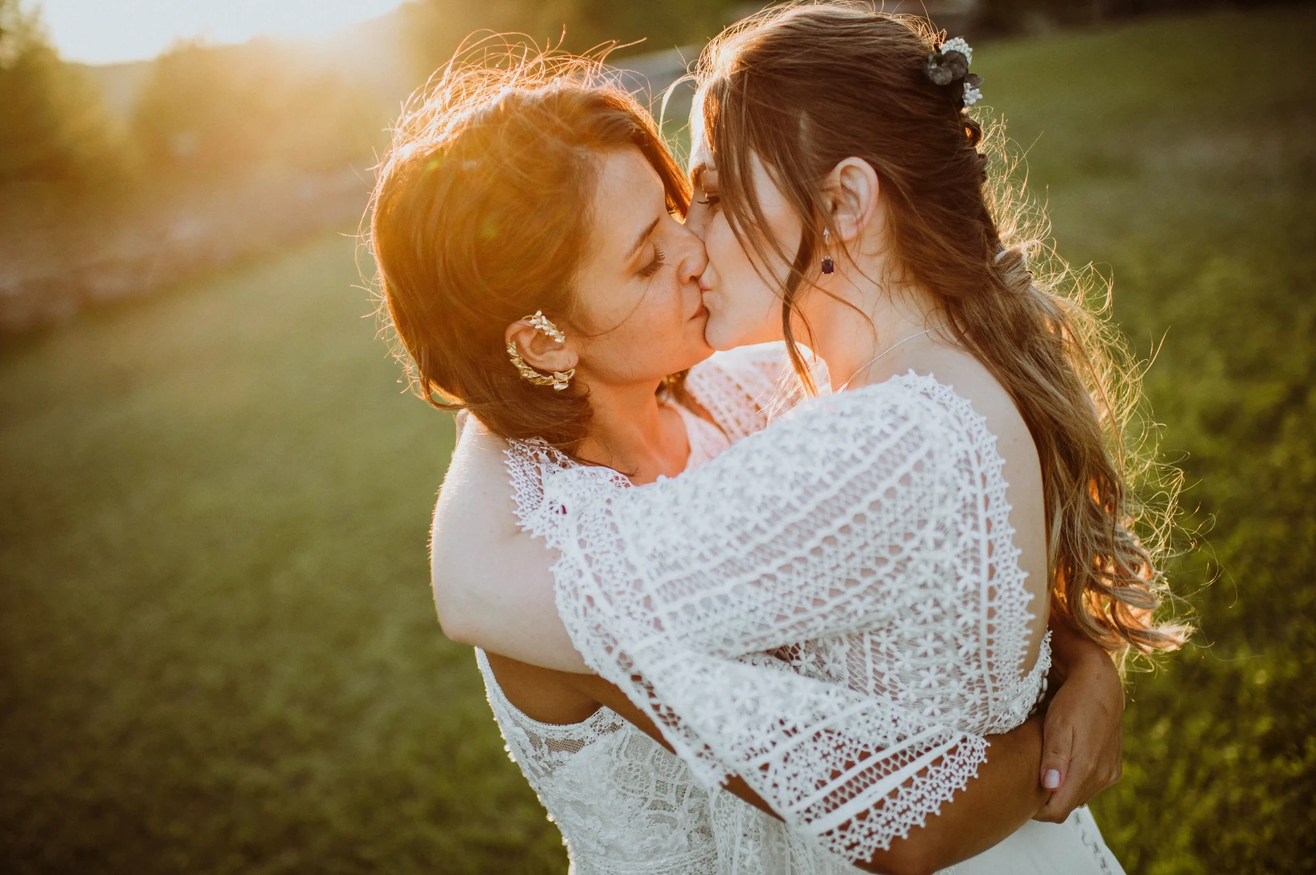 boda LGTBI en Ca n'Alzina — beso íntimo de las novias abrazadas con luz dorada del atardecer