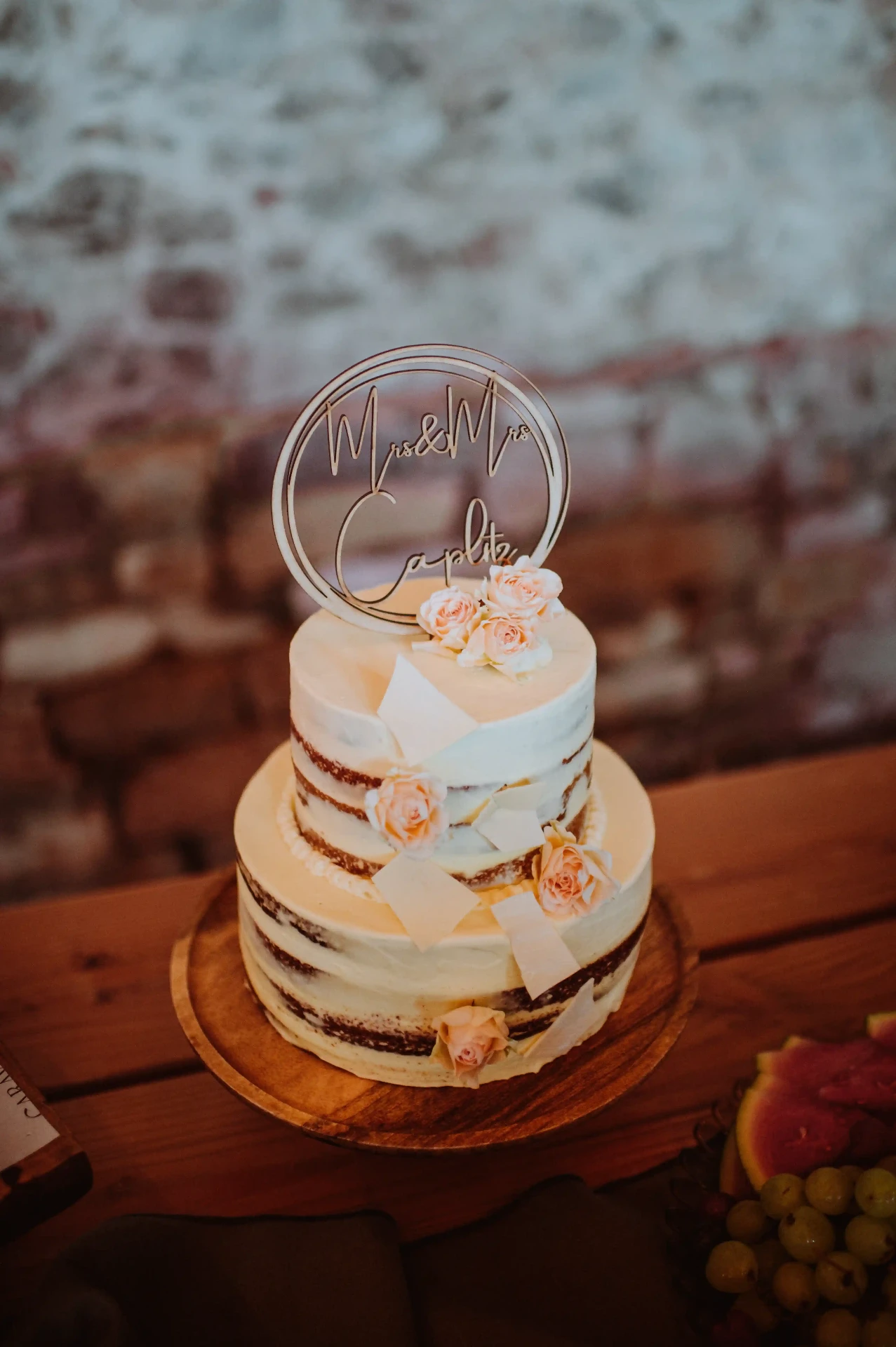 Tarta nupcial de dos pisos con topper 'Mrs & Mrs' y rosas rosadas en la cena country de This Must Be The Place