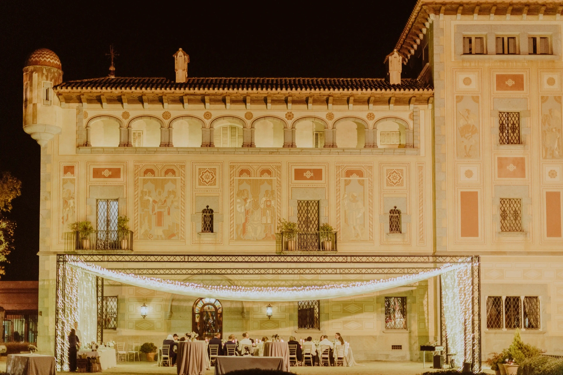 Fachada iluminada de Bell Recó Argentona de noche con cortina de luces sobre el banquete al aire libre