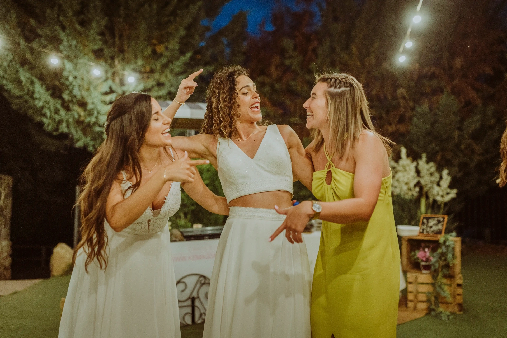 boda LGTBI en El Xaloc, Calders — las novias cantan y bailan abrazadas a una amiga en la fiesta