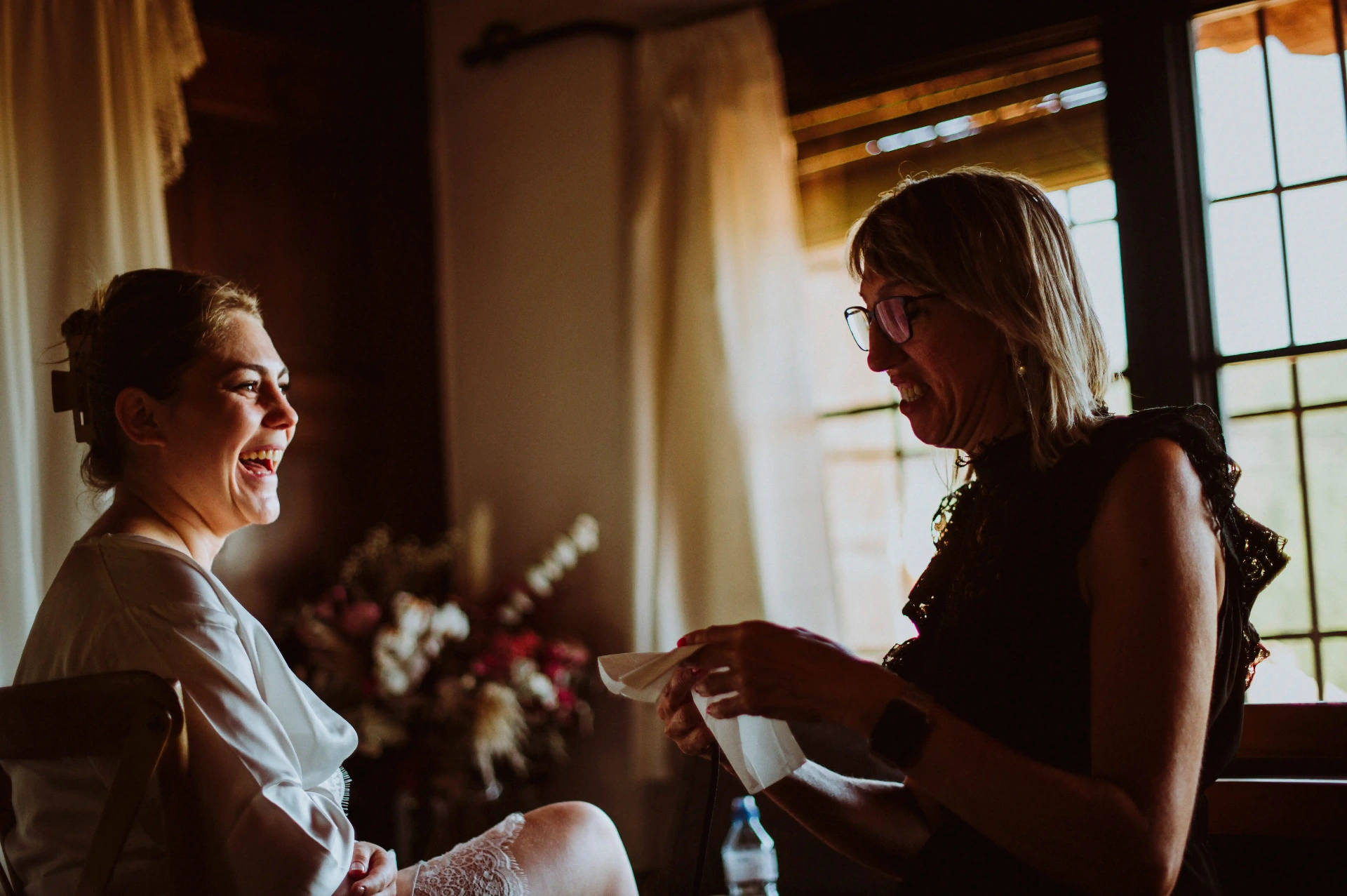 boda LGTBI en Ca n'Alzina — novia riendo con una amiga durante los preparativos