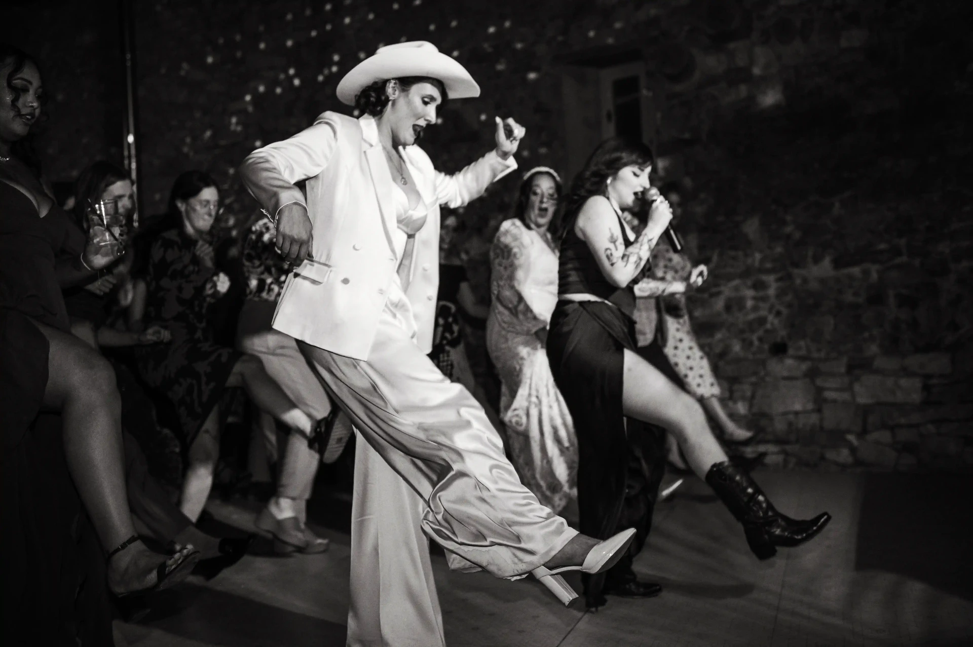 Fotografía en blanco y negro de la novia bailando country con sombrero cowboy en la fiesta de This Must Be The Place
