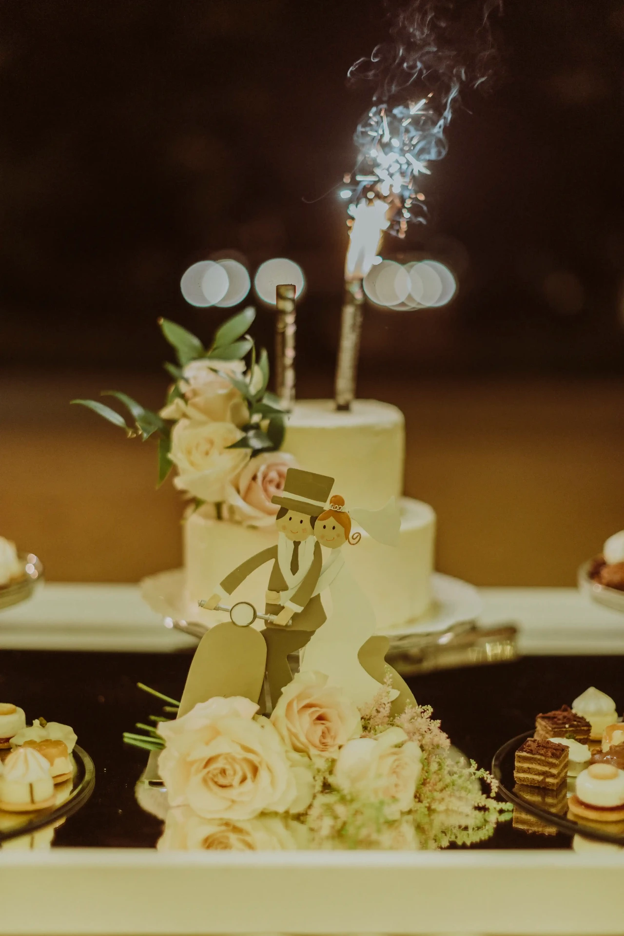 Tarta nupcial con bengala encendida y figurita de Vespa en la mesa dulce de la boda en Bell Recó