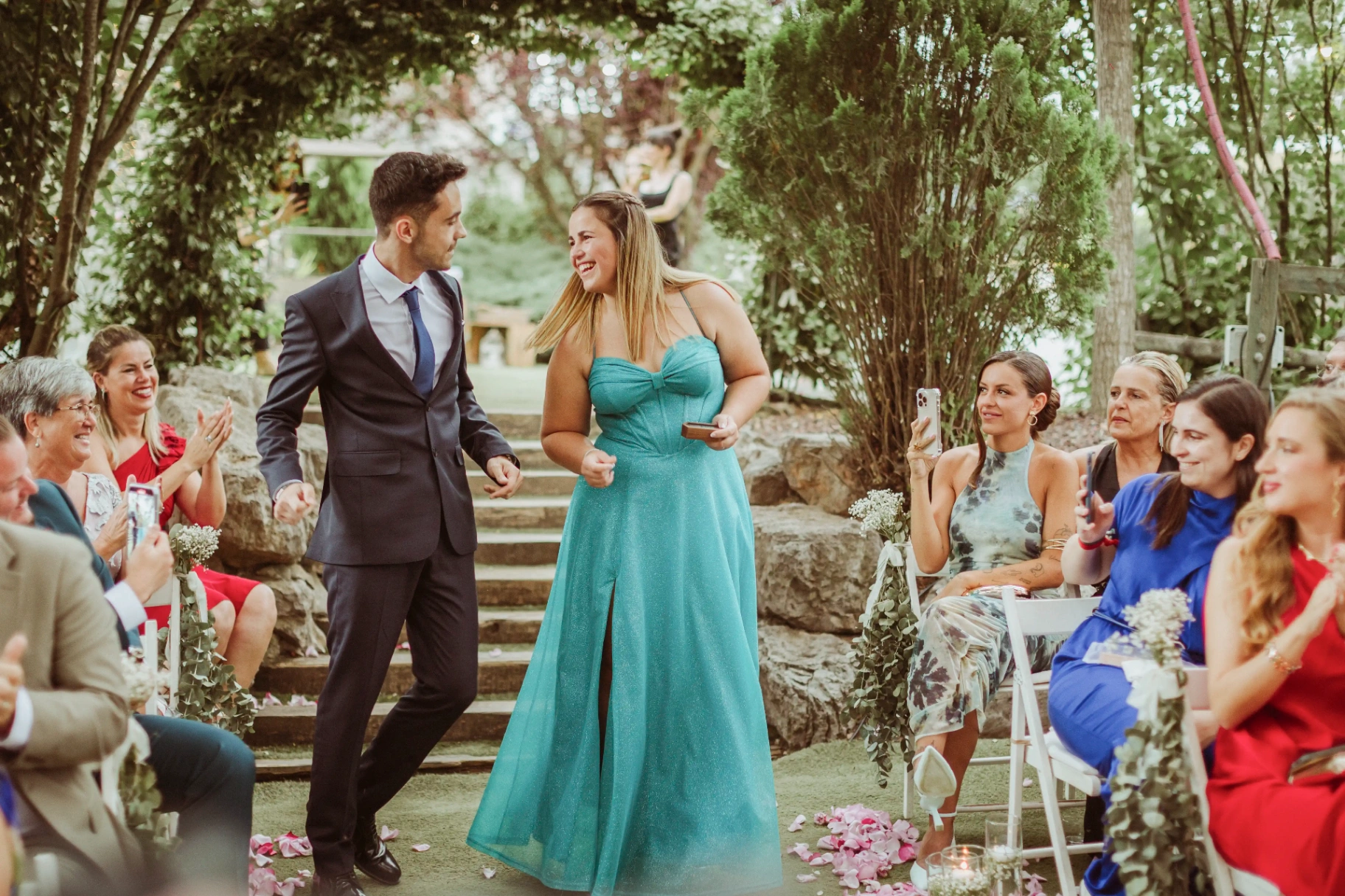 boda LGTBI en El Xaloc, Calders — los padrinos entran por el pasillo con las alianzas ante los invitados