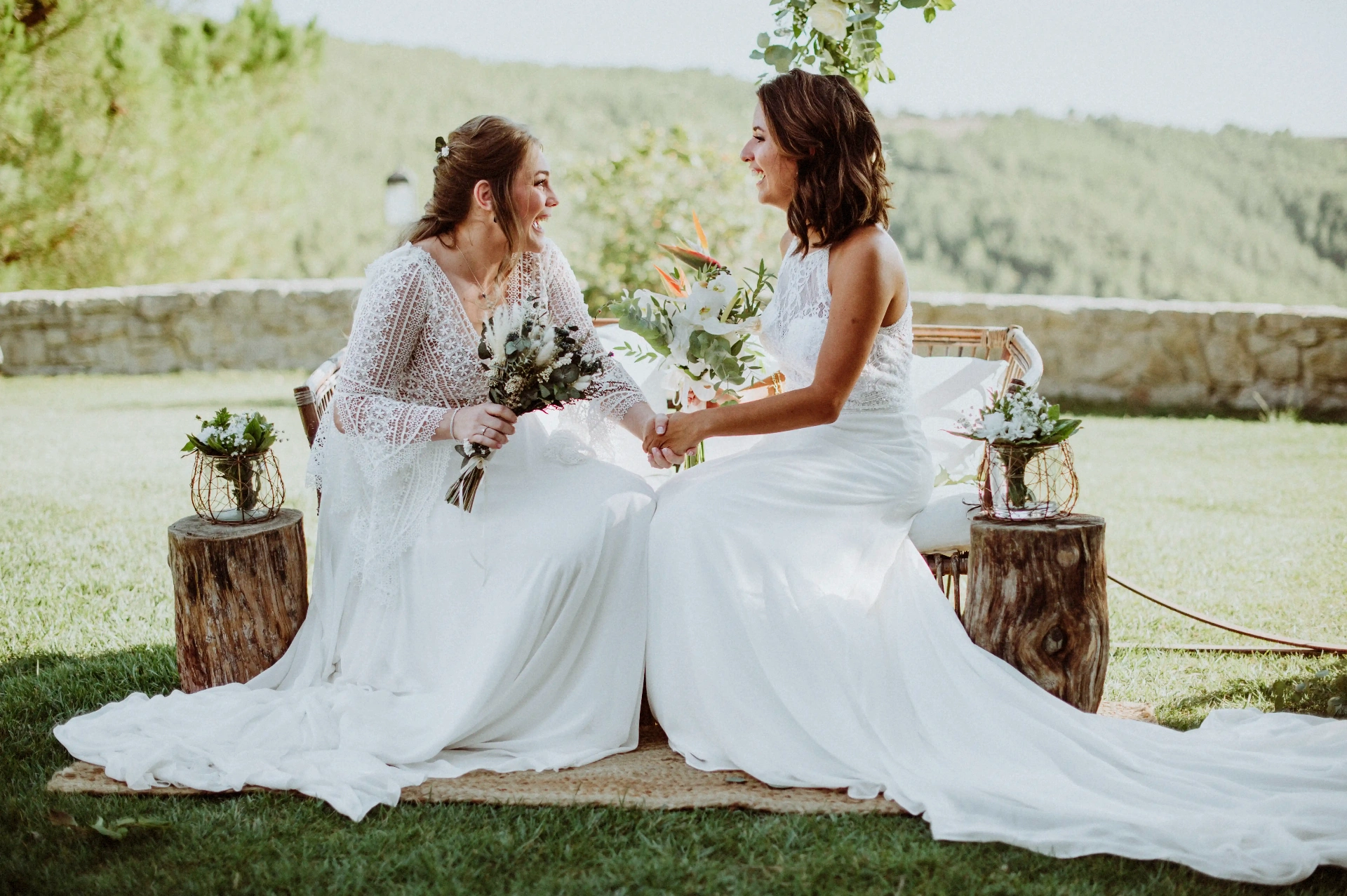 boda LGTBI en Ca n'Alzina (Rubió) — las dos novias sentadas de la mano riendo tras la ceremonia