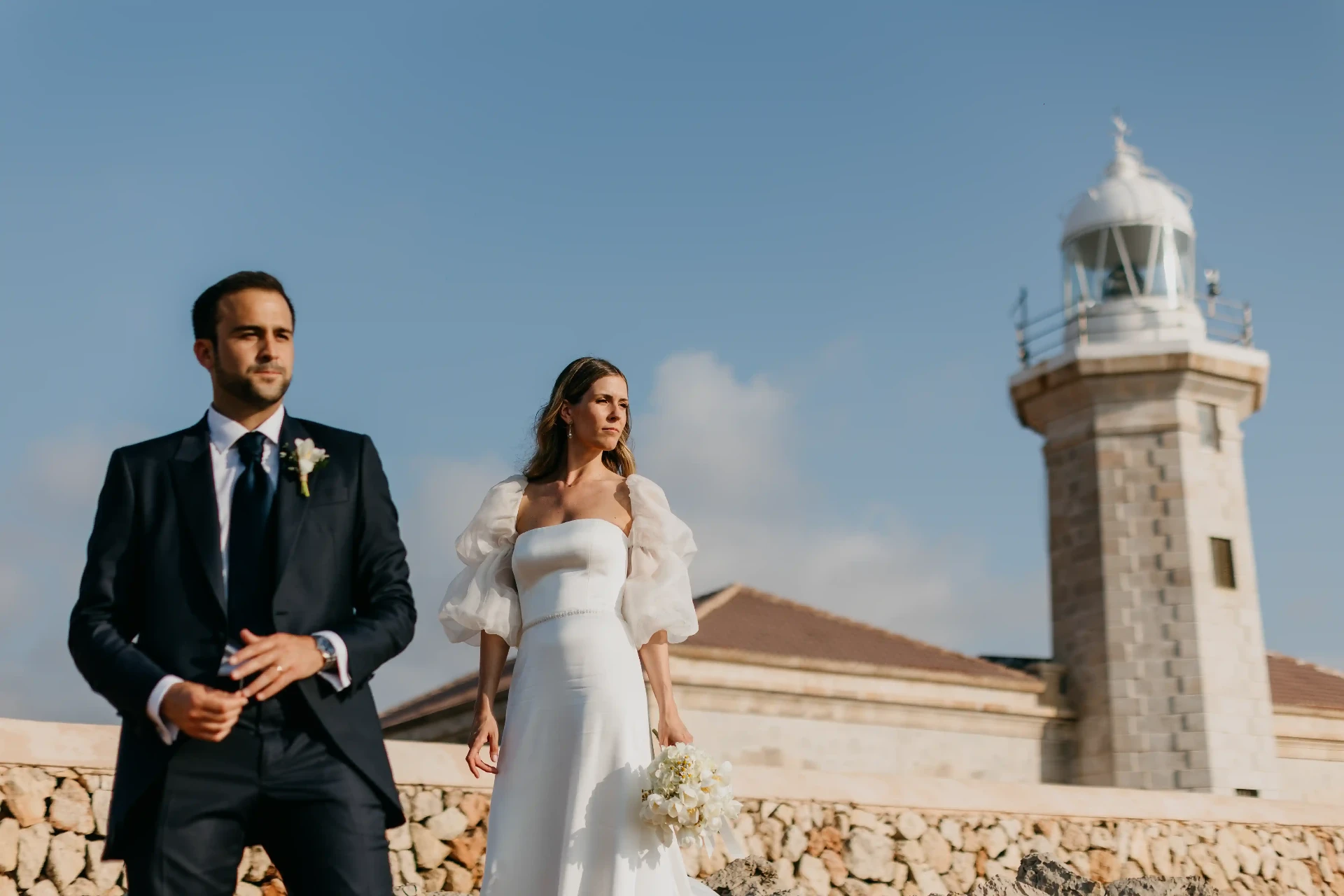 Novios posando frente al Faro de Cap d'Artrutx en una boda en Menorca. Piña Colada