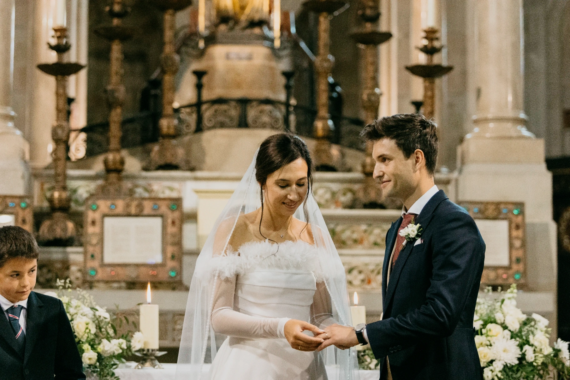 Intercambio de anillos entre Joan y Núria frente al altar barroco de Santa Maria de Cervera, ceremonia boda Lleida
