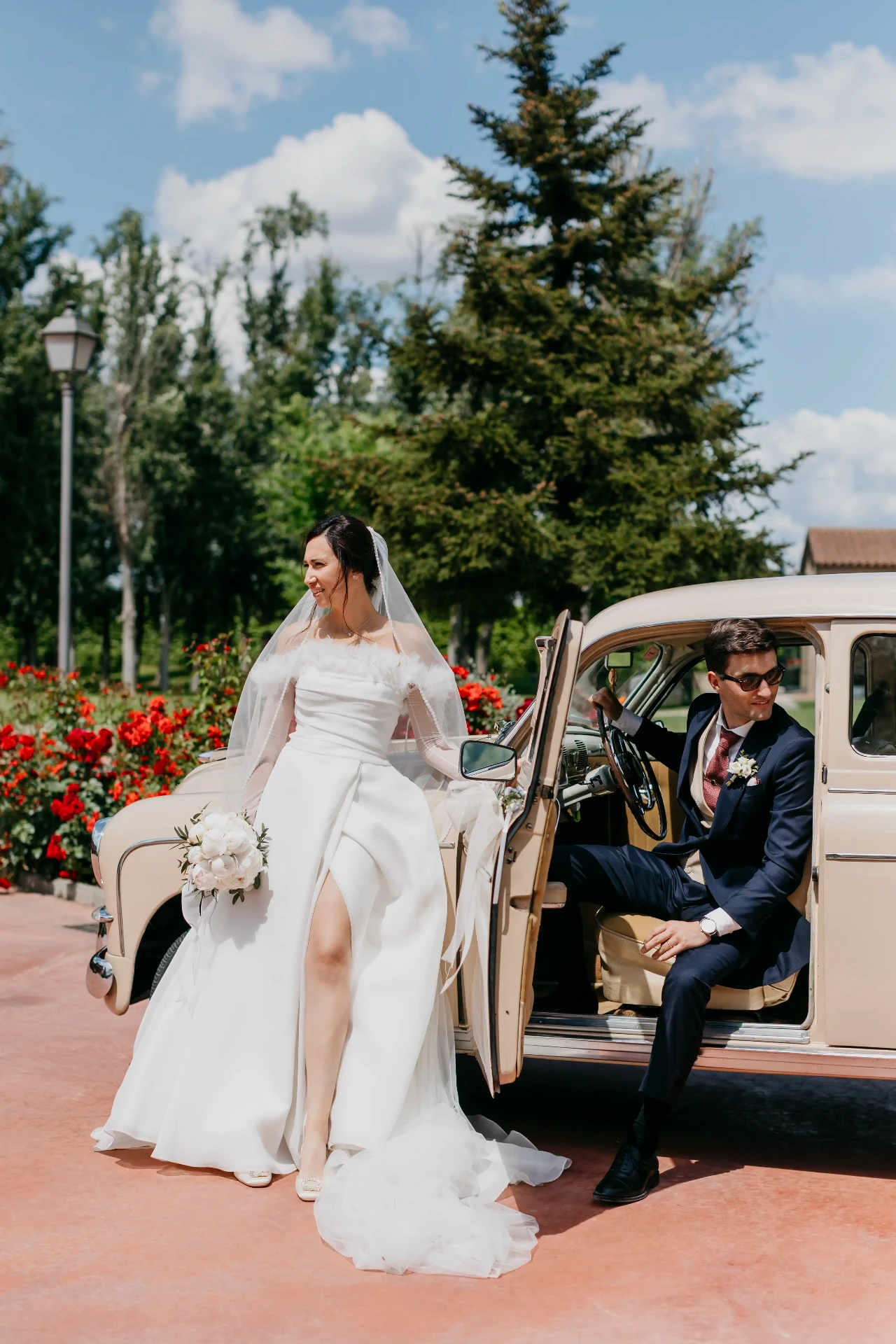 Novia junto a coche clásico beige mientras el novio se apea, retrato de novios en La Boscana (Lleida)