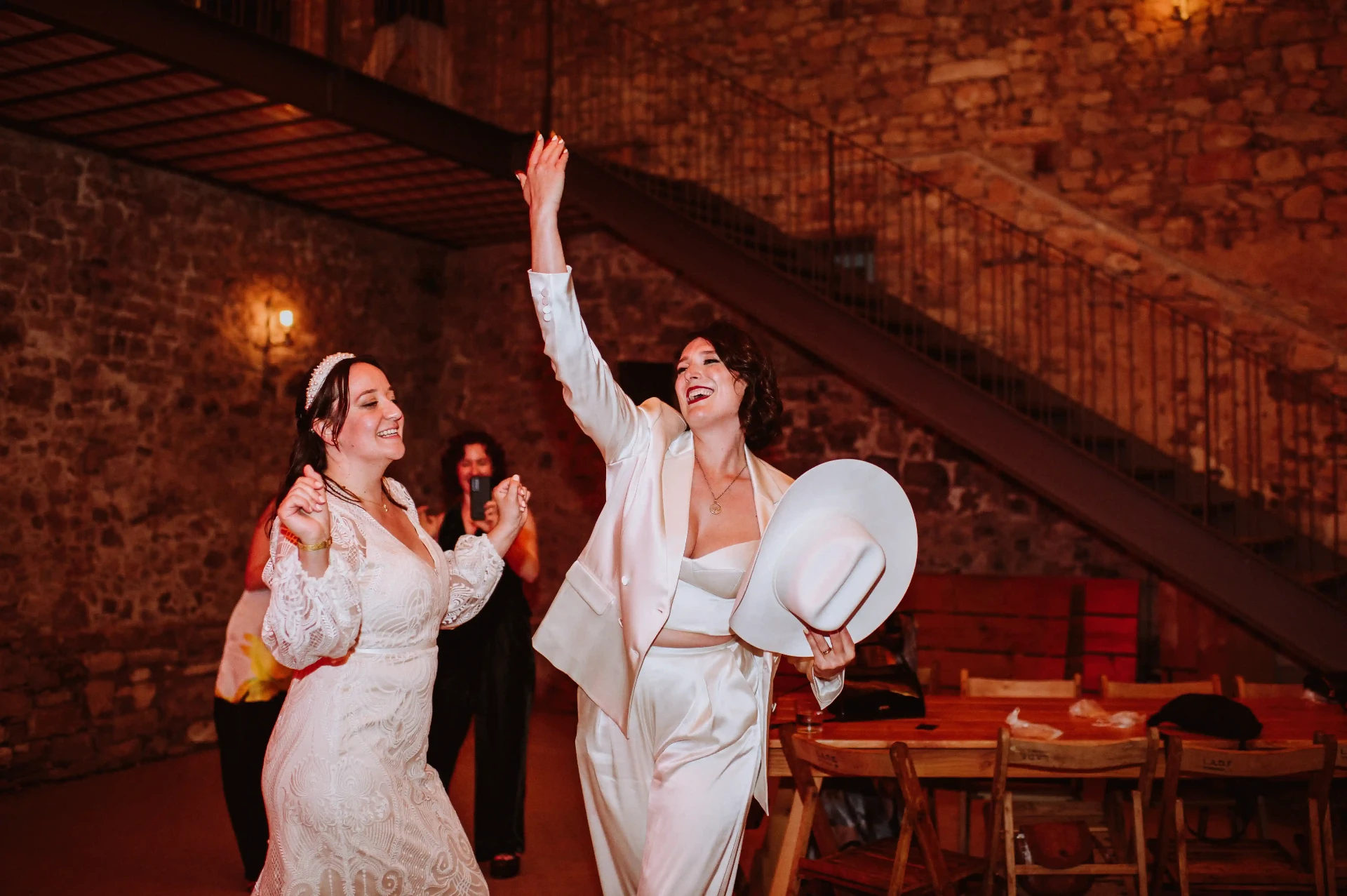 Las novias celebrando en la pista de baile de la masía de piedra de This Must Be The Place