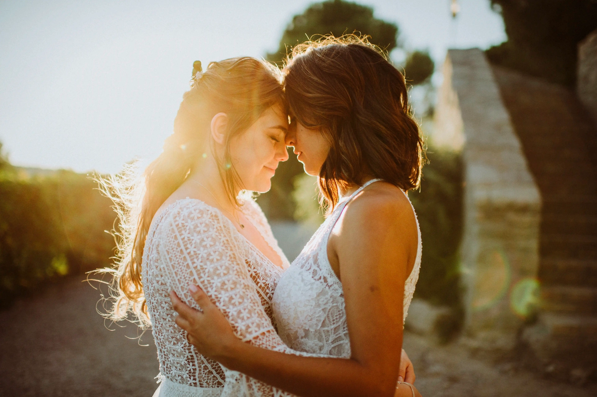 boda LGTBI en Ca n'Alzina — retrato íntimo de las novias frente con frente con destellos de sol al atardecer