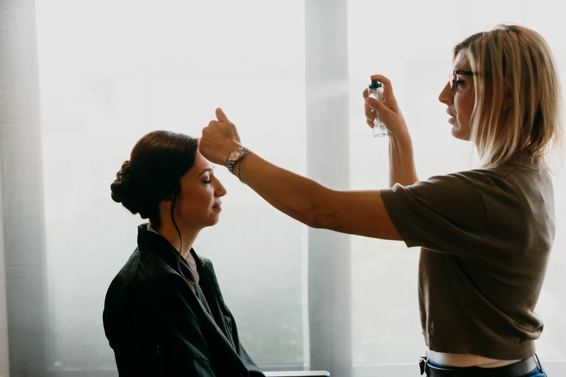Novia recibiendo el maquillaje y peinado con luz natural, preparativos boda La Boscana Lleida