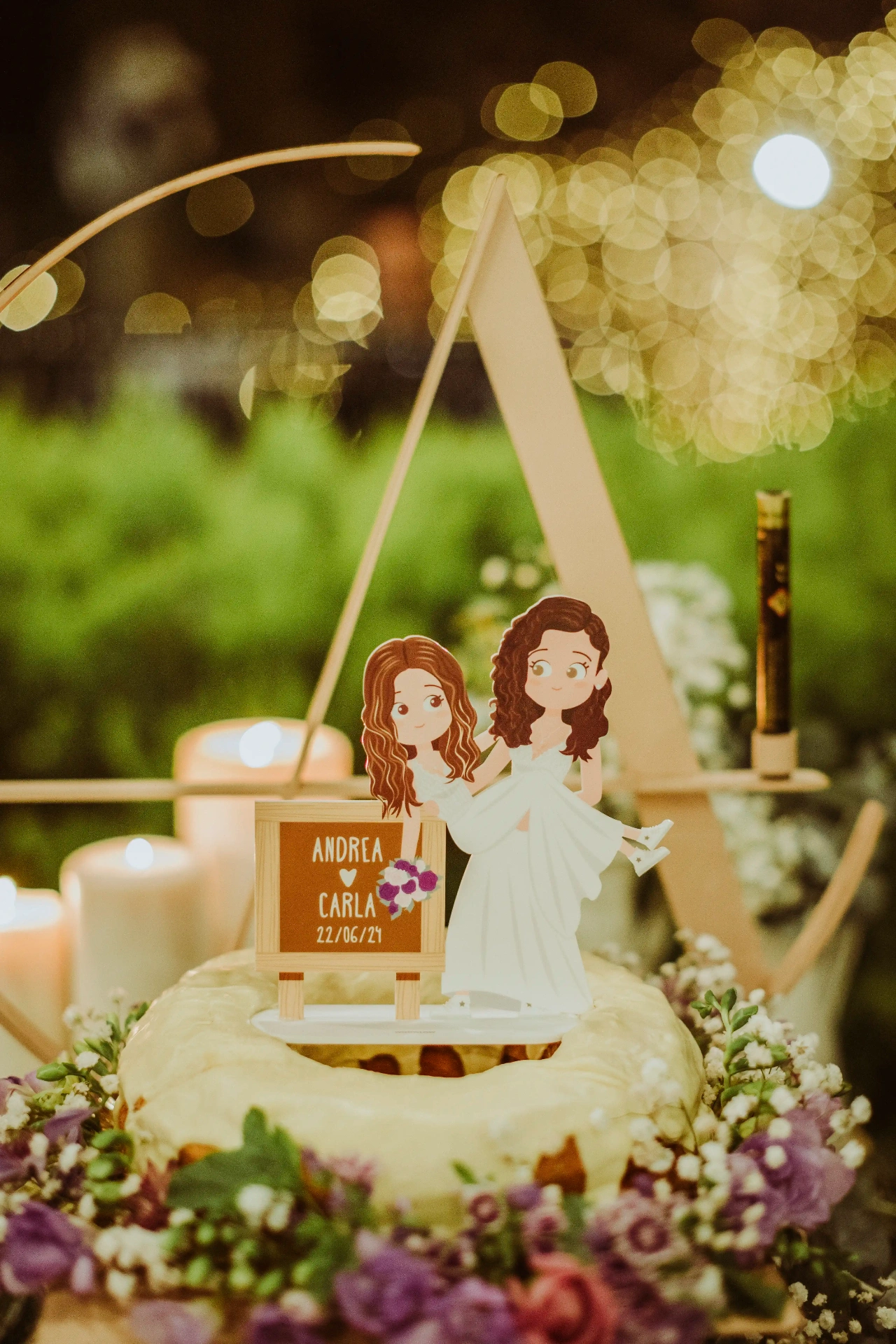 boda LGTBI en El Xaloc, Calders — cake topper personalizado de Andrea y Carla sobre la tarta rodeada de flores