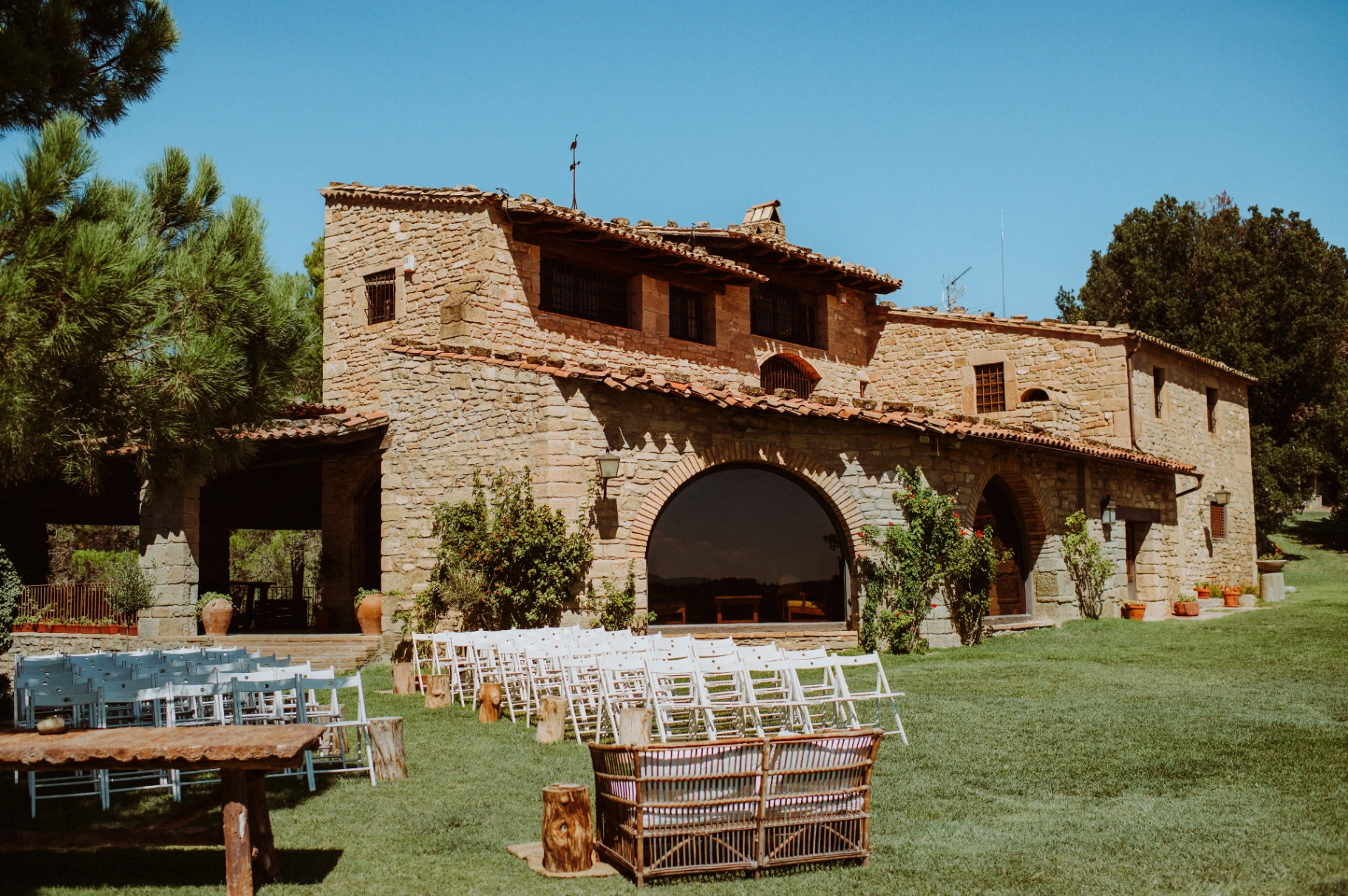 boda LGTBI en Ca n'Alzina (Rubió) — fachada de piedra de la masía con la ceremonia montada en el jardín