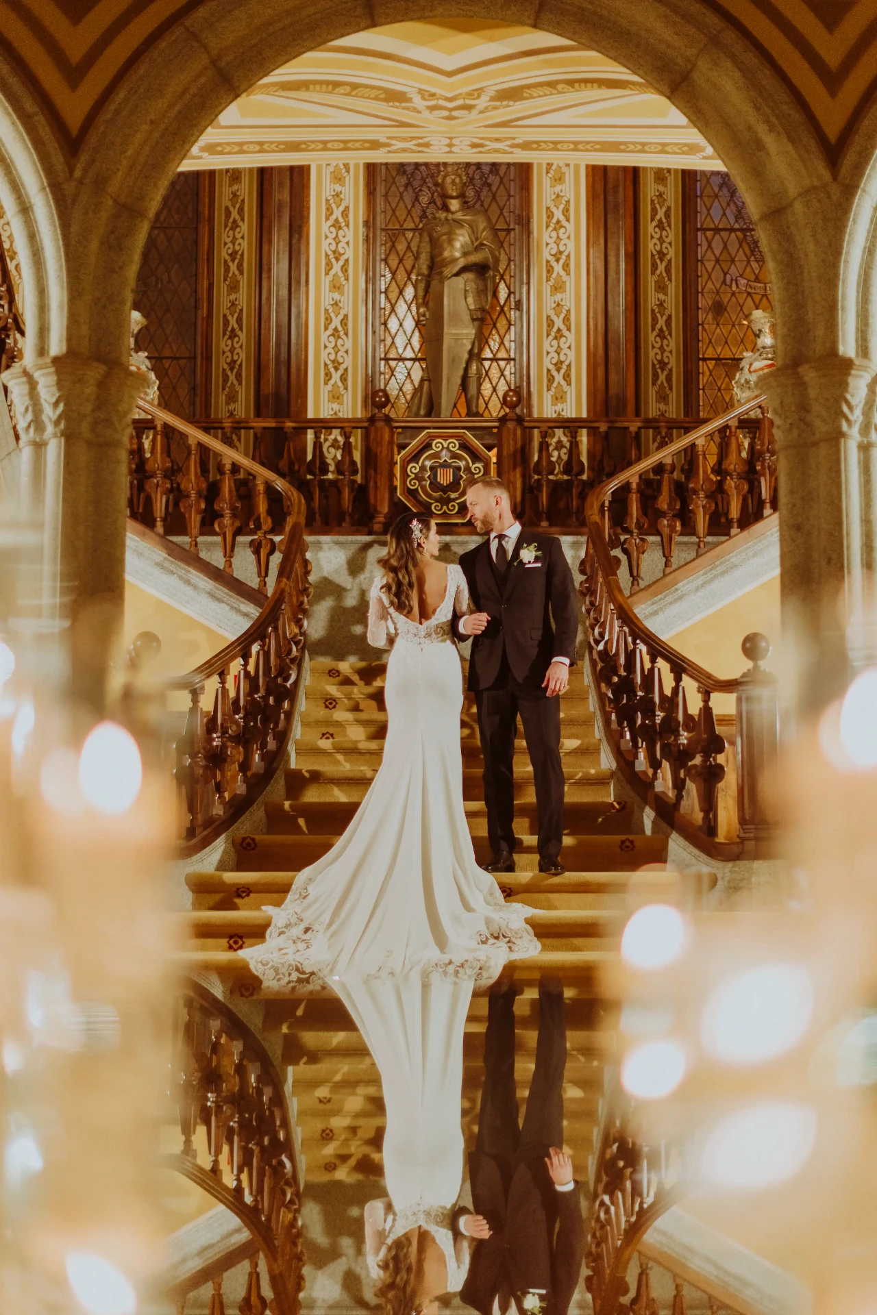 Ana y Lee en la escalinata señorial de Bell Recó con vestido de cola larga y reflejo, destination wedding Barcelona
