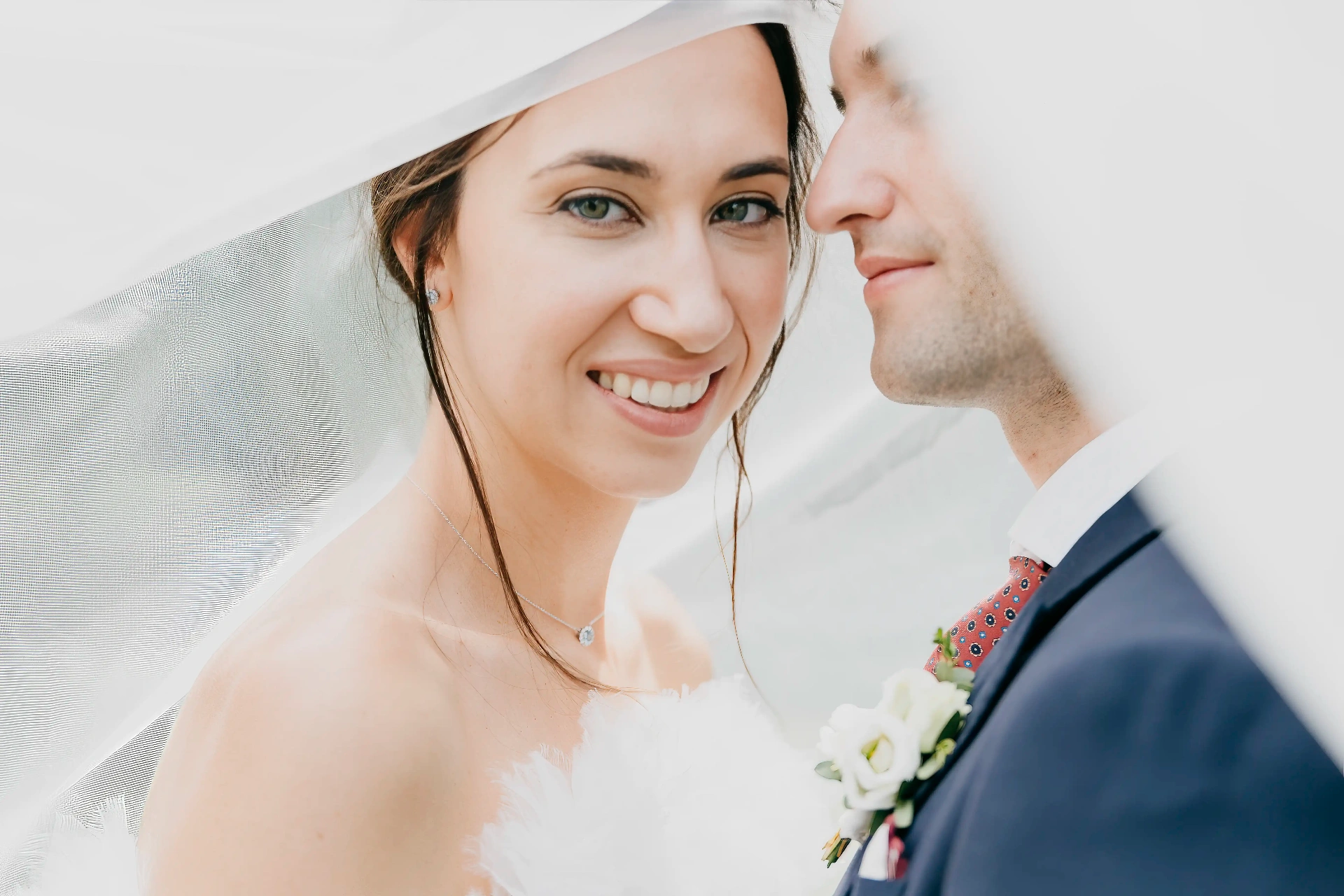 Retrato de Núria sonriendo bajo el velo junto a Joan con luz suave, fotografía natural boda La Boscana Lleida