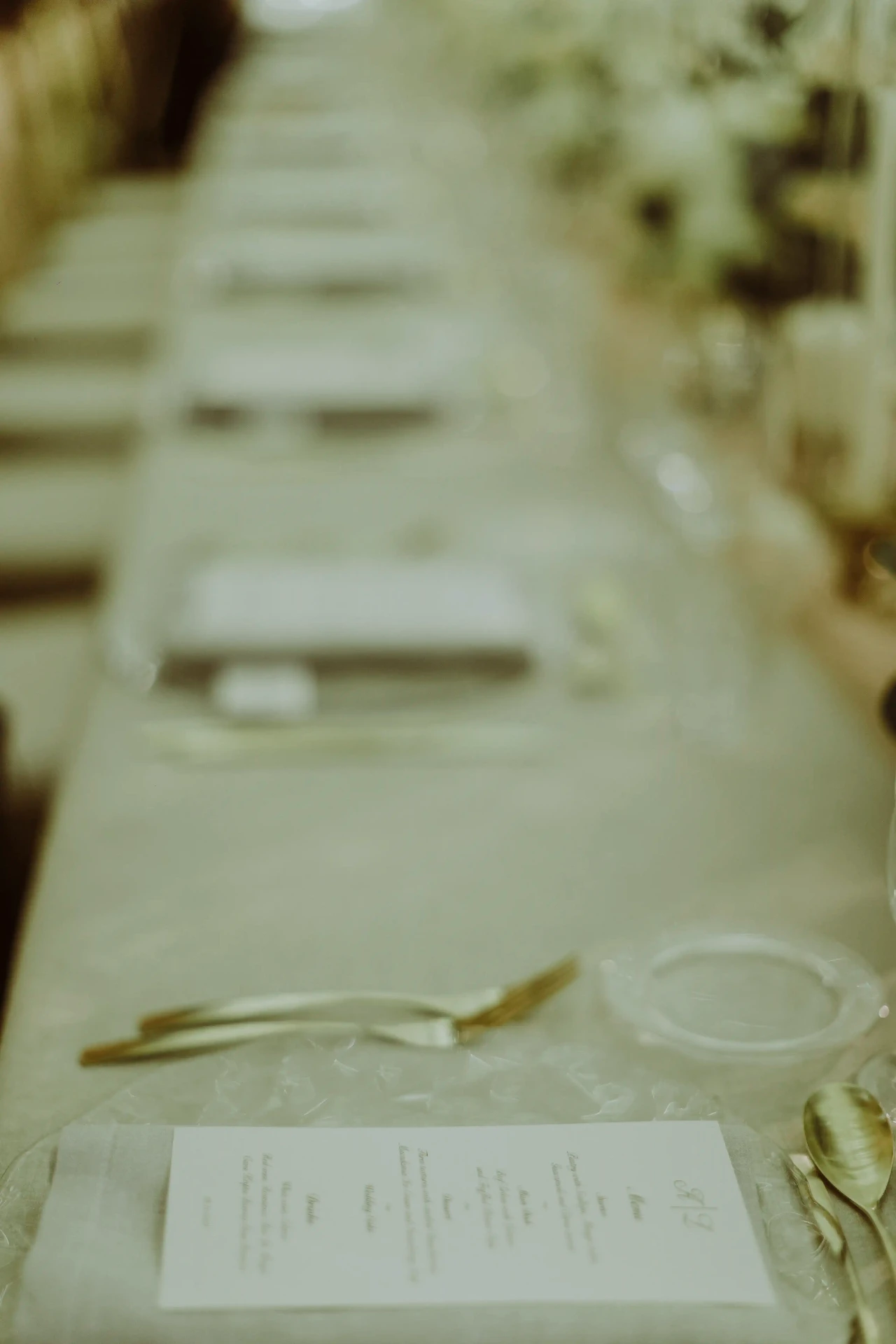 Enfilada de menús y cubertería dorada sobre mesa imperial del banquete de boda en Bell Recó Argentona