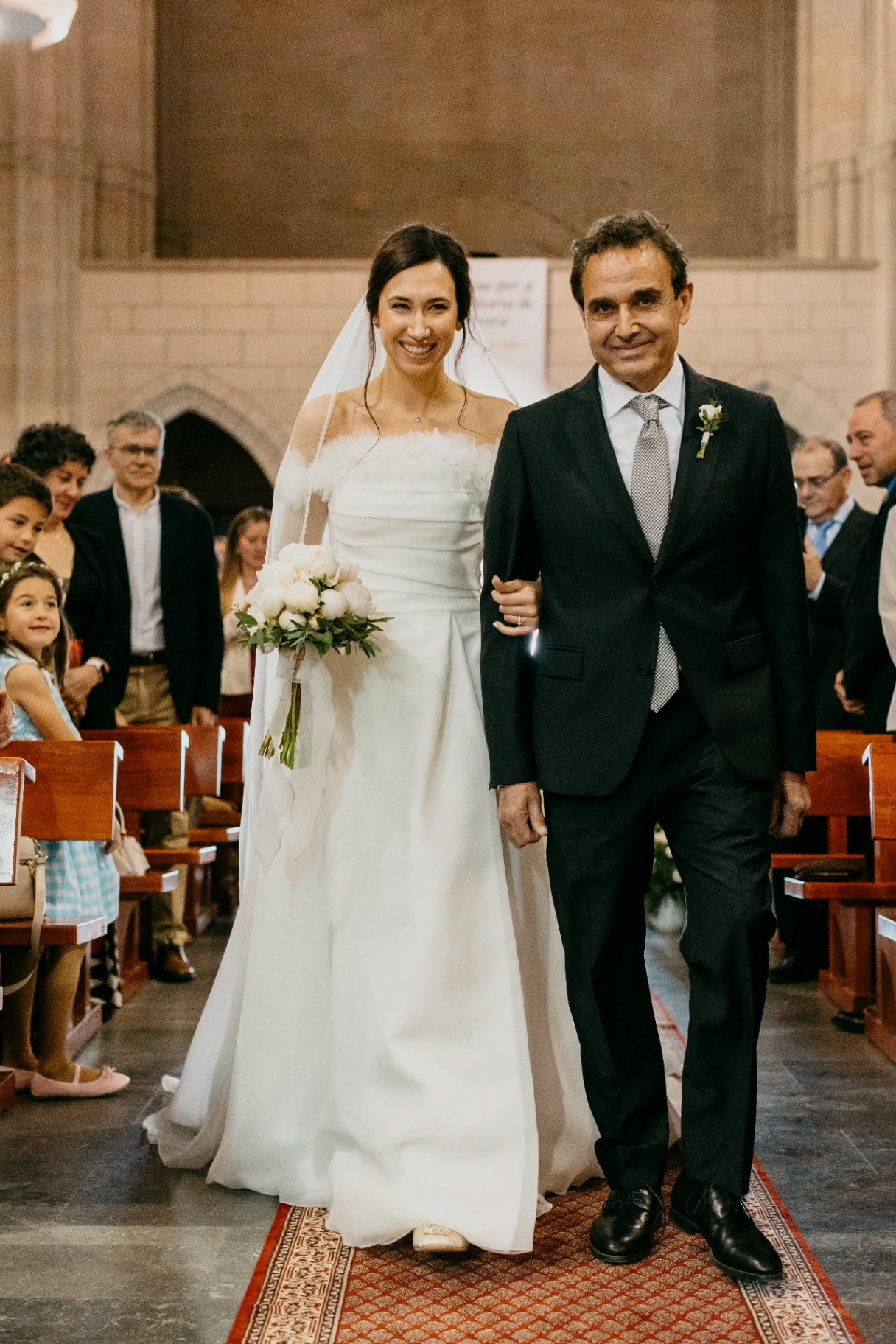 Núria entrando del brazo de su padre por el pasillo de la iglesia, ceremonia boda en Cervera (Lleida)
