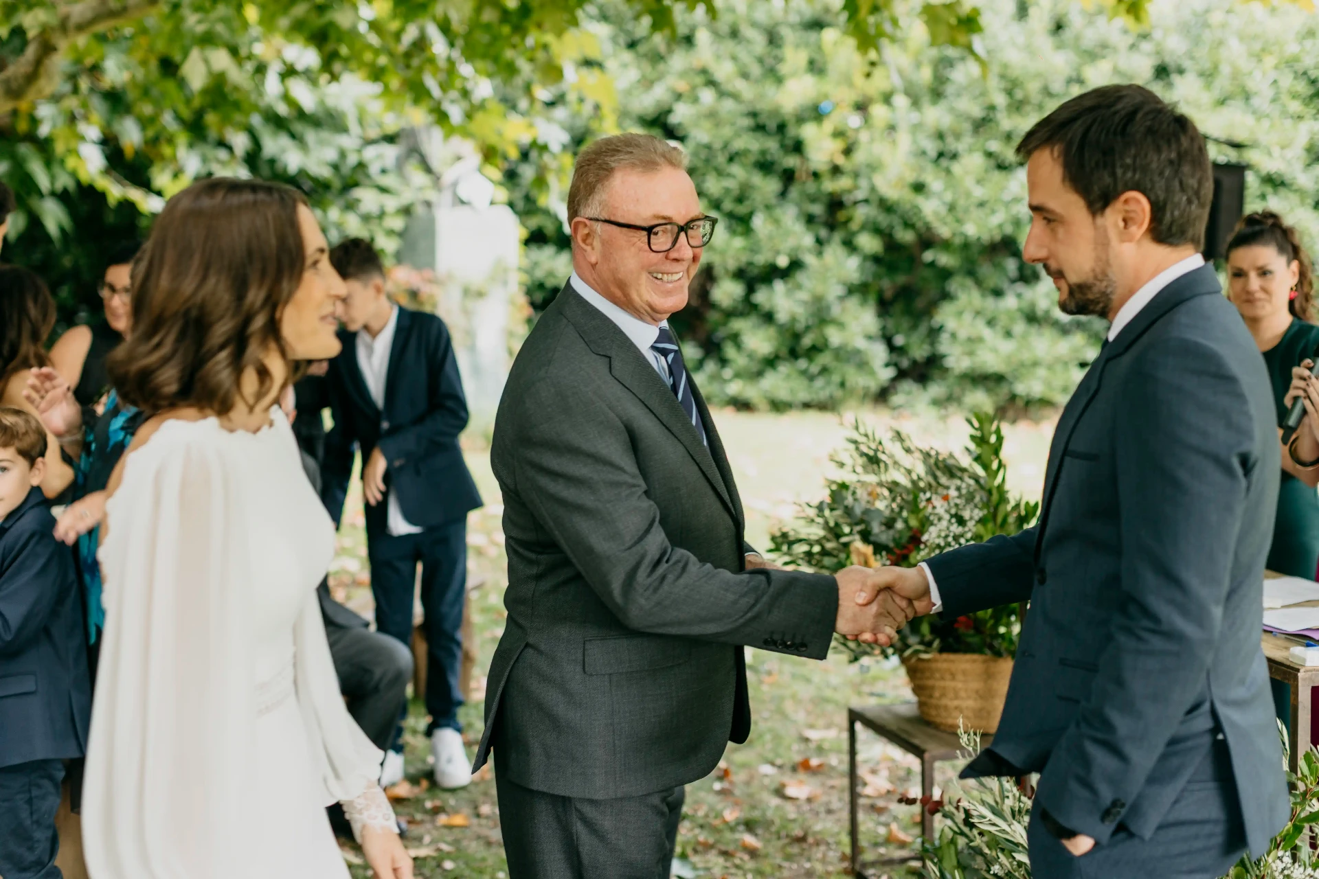 Padre de la novia dando la mano a Dani durante la ceremonia al aire libre en Can Riera de la Pineda