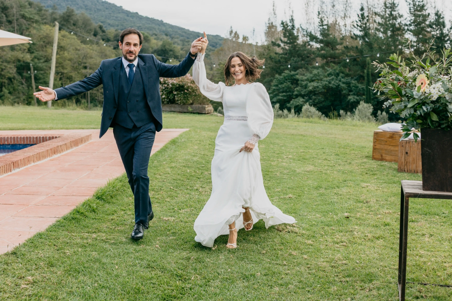 Entrada al banquete de Carla y Dani bailando cogidos de la mano junto a la piscina de Can Riera de la Pineda