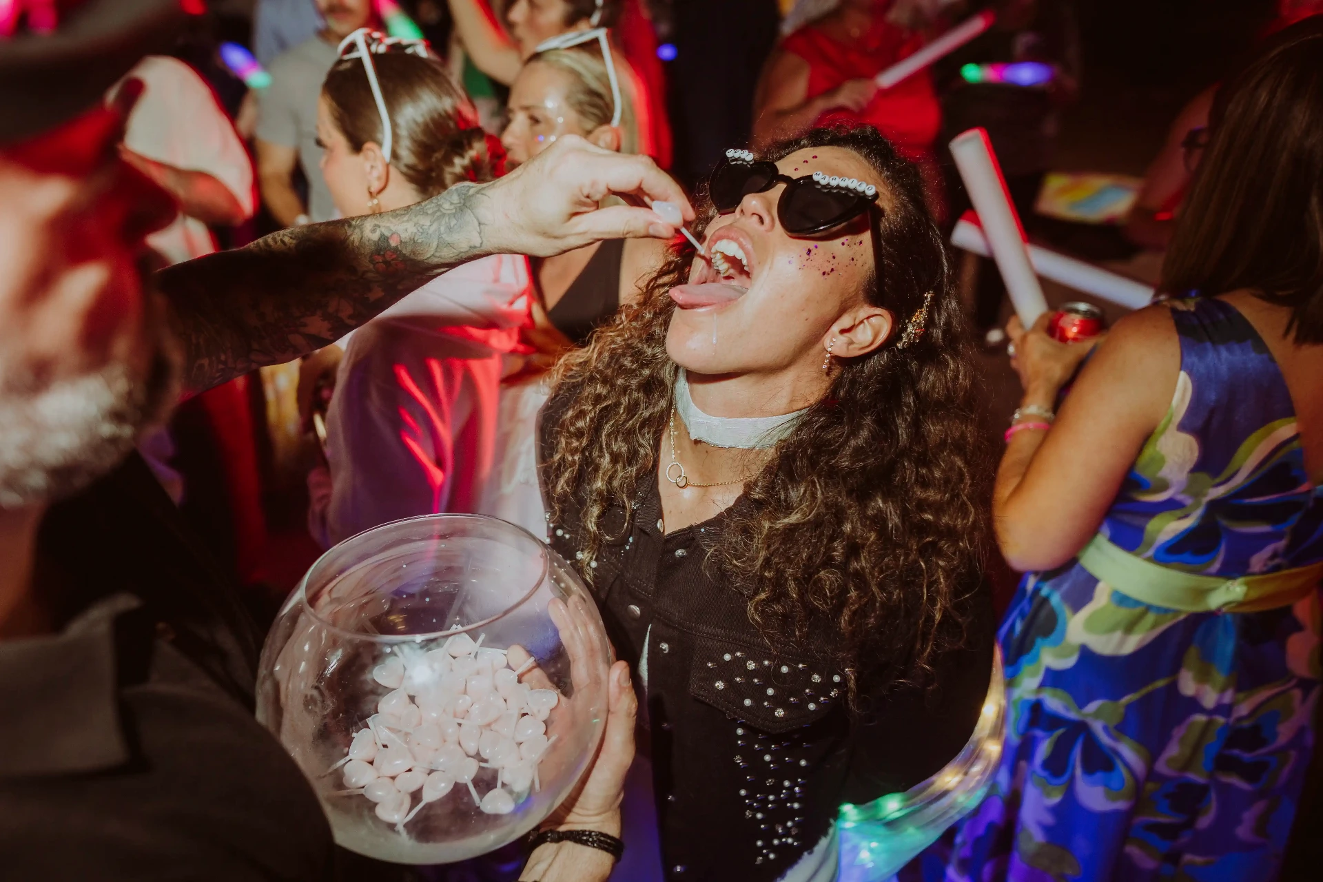 boda LGTBI en El Xaloc, Calders — chupito sorpresa a una de las novias con gafas de sol y purpurina en plena pista