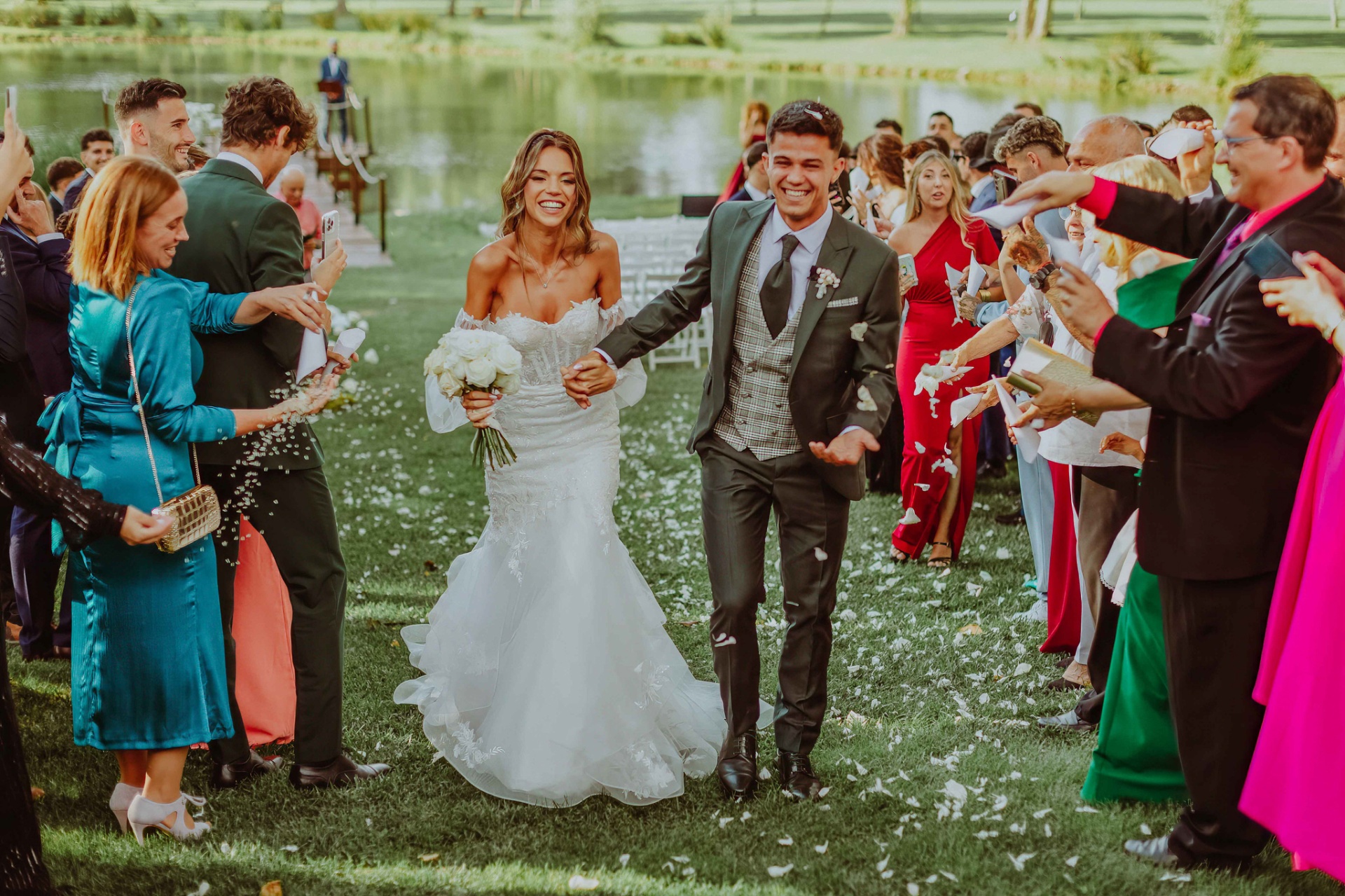 Alba y Roger caminando entre los invitados con lluvia de pétalos y confeti tras la ceremonia
