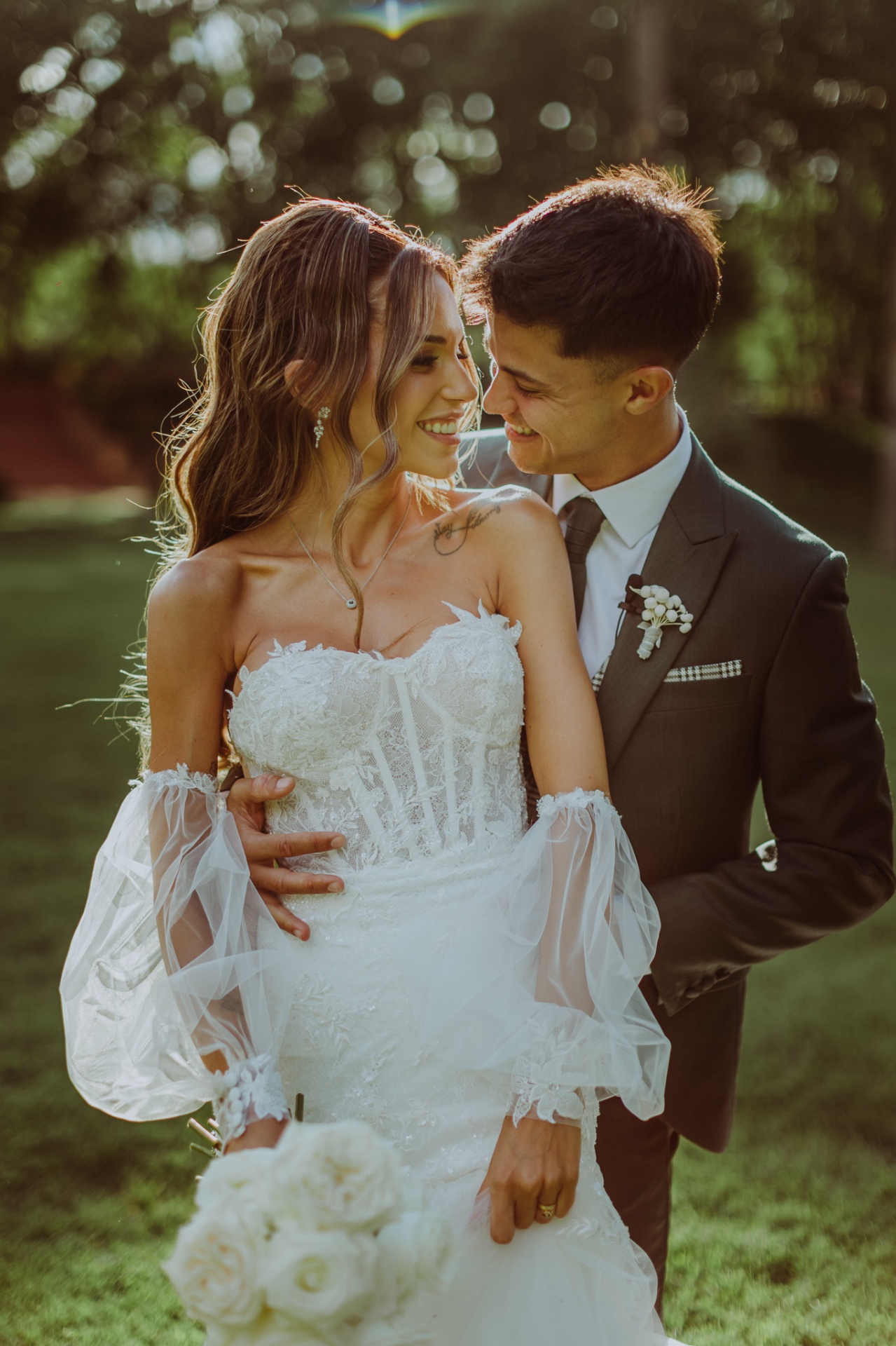 Retrato romántico de Alba y Roger mirándose con luz dorada del atardecer en los jardines de La Farinera