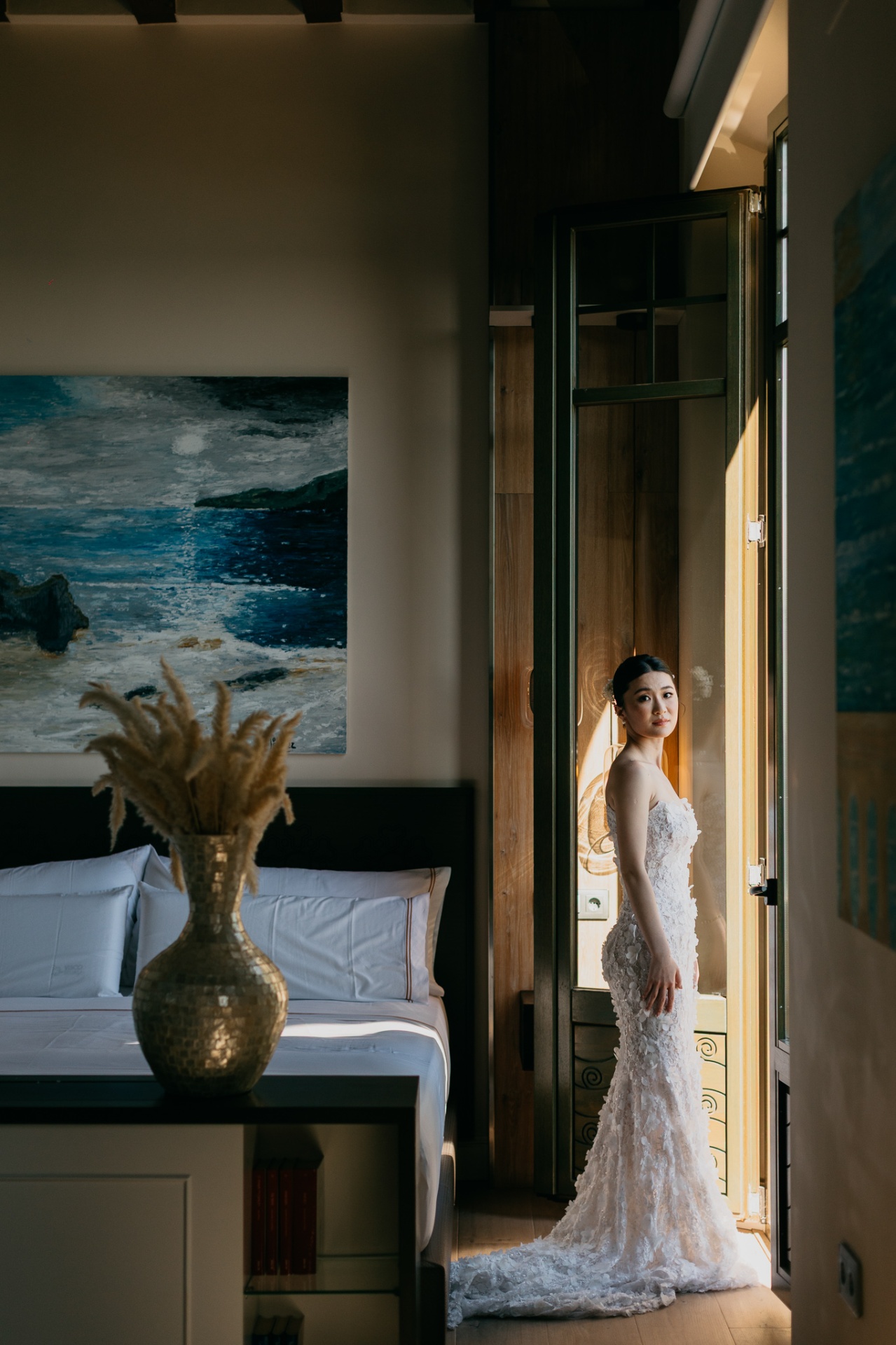 Kara standing in a doorway at Xalet del Nin framed by a seascape painting and golden vase