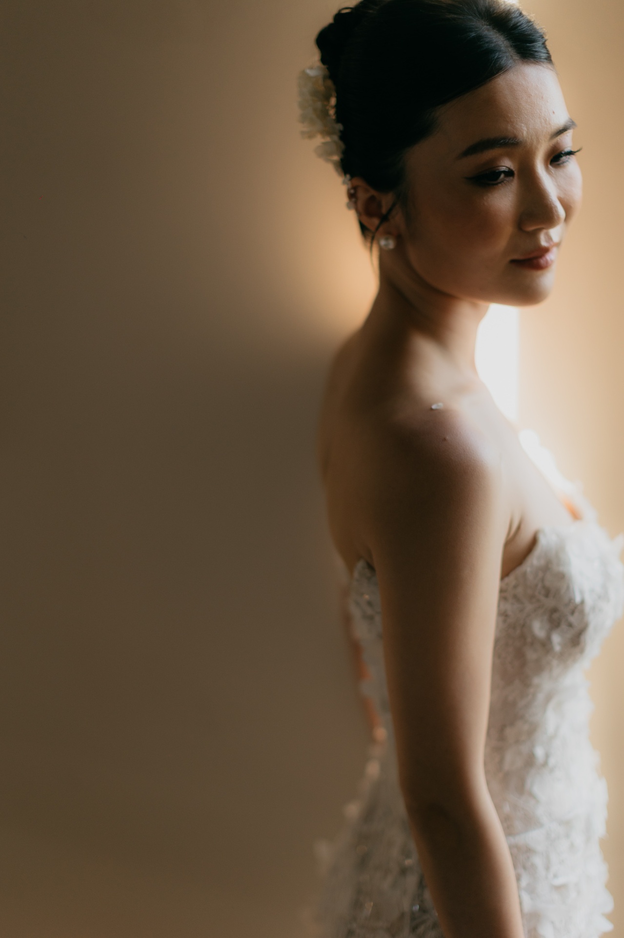 Intimate portrait of Kara with pearl earrings and floral headpiece in warm golden light