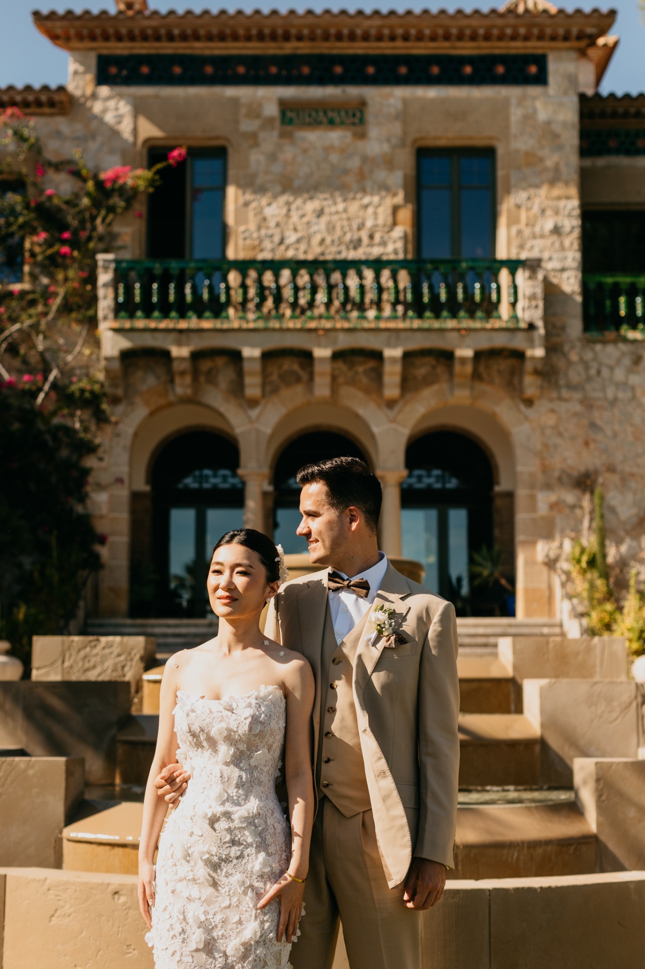 Couple portrait in front of the stone facade of Xalet del Nin with Mediterranean architecture