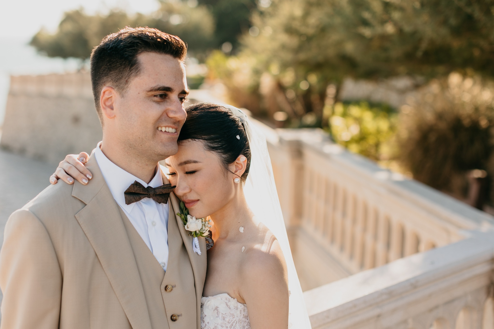 Cameron and Kara in a tender embrace on the seaside terrace at golden hour at Xalet del Nin