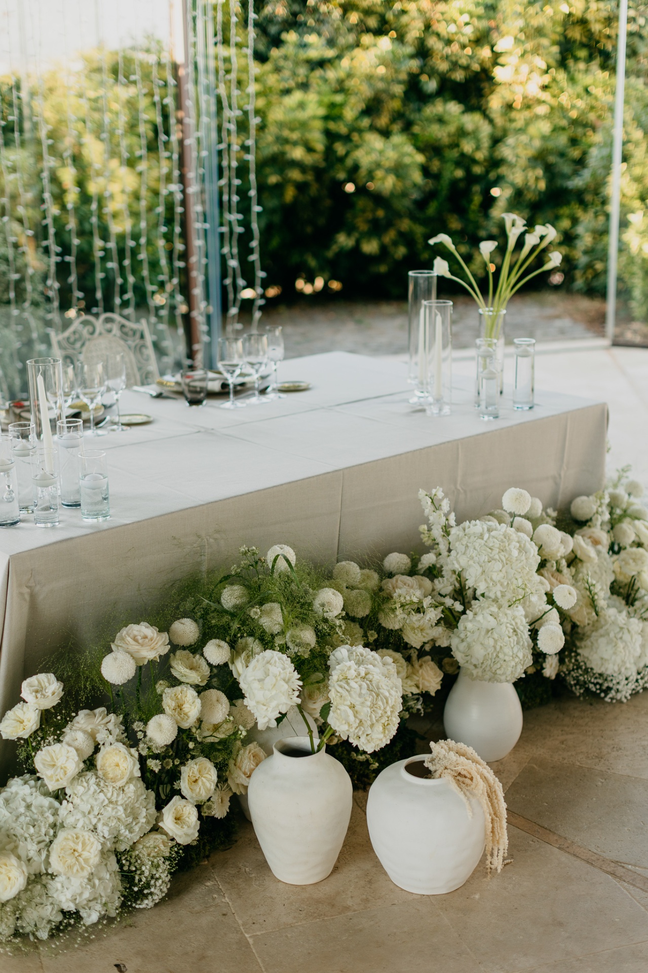 Elegant white floral arrangement with hydrangeas and calla lilies at the dinner table at Xalet del Nin