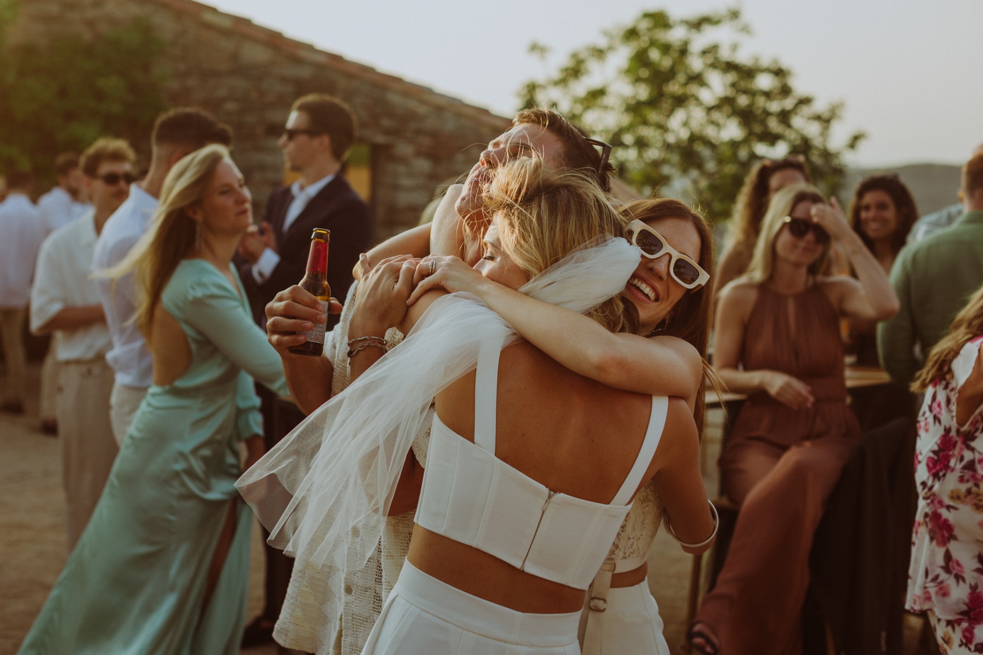 Bride hugging friend with joy during cocktail reception