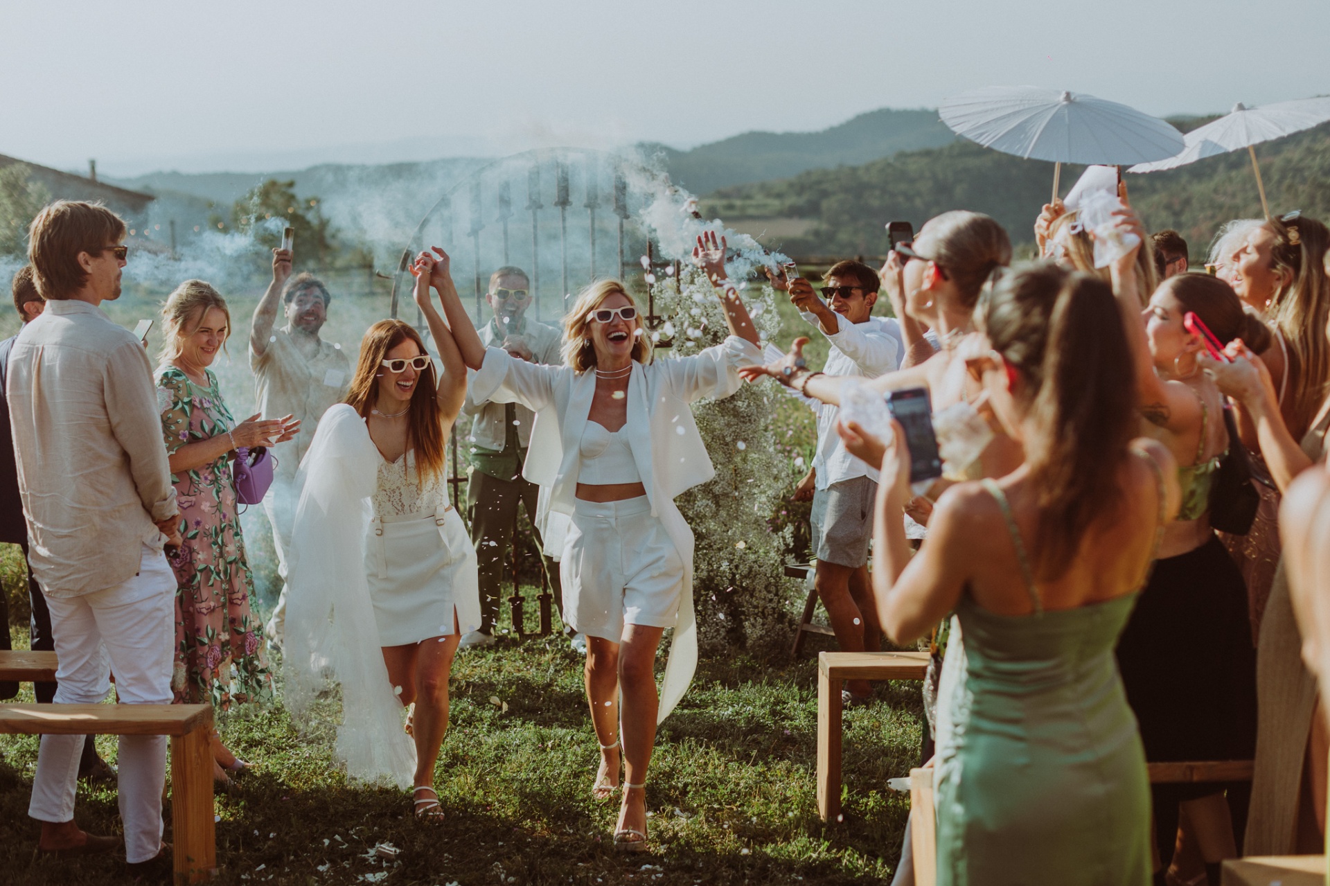 Chiara and Ro celebrating with confetti and smoke bombs after ceremony