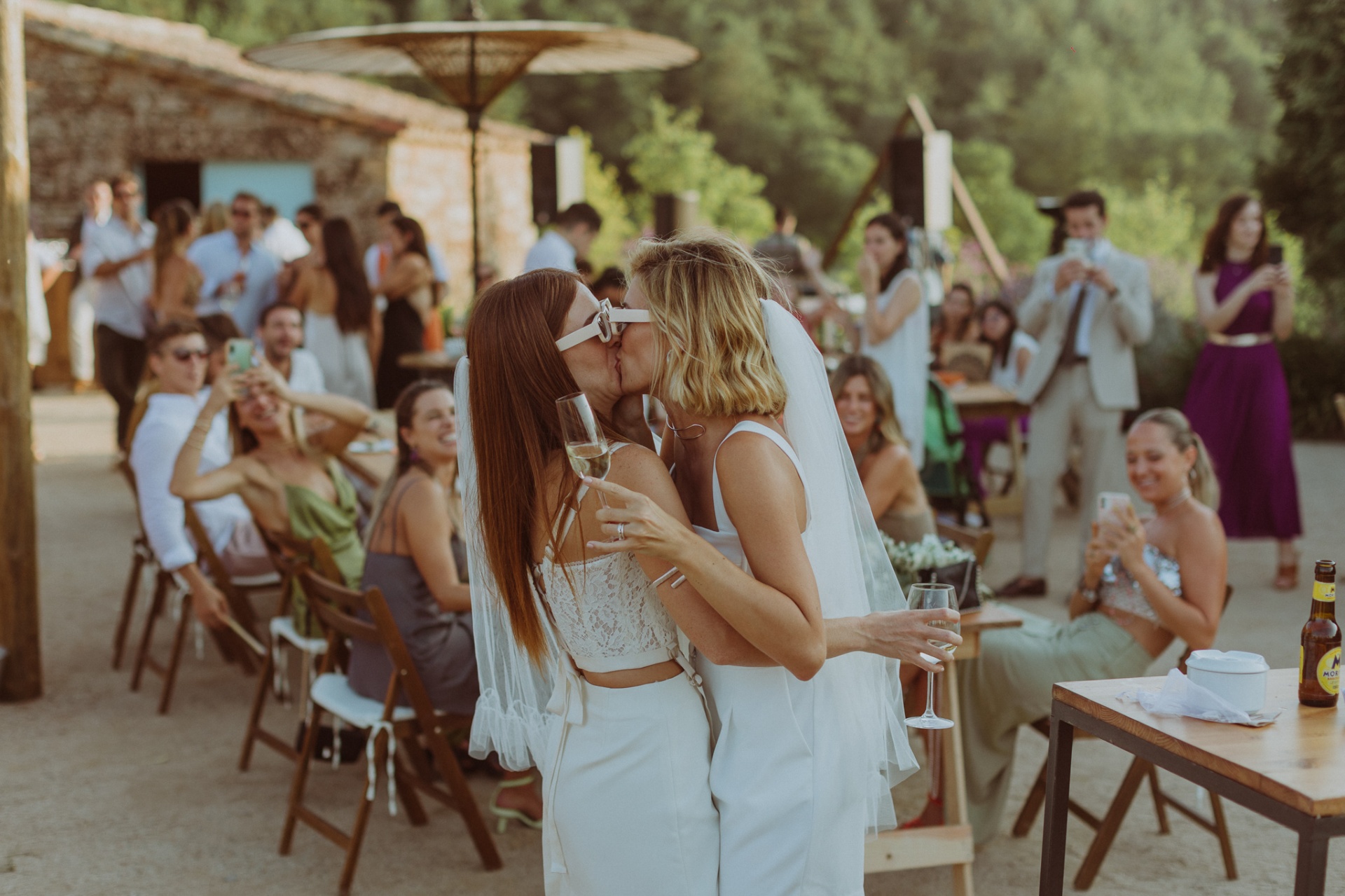 Spontaneous kiss between brides during cocktail hour at TMBTP